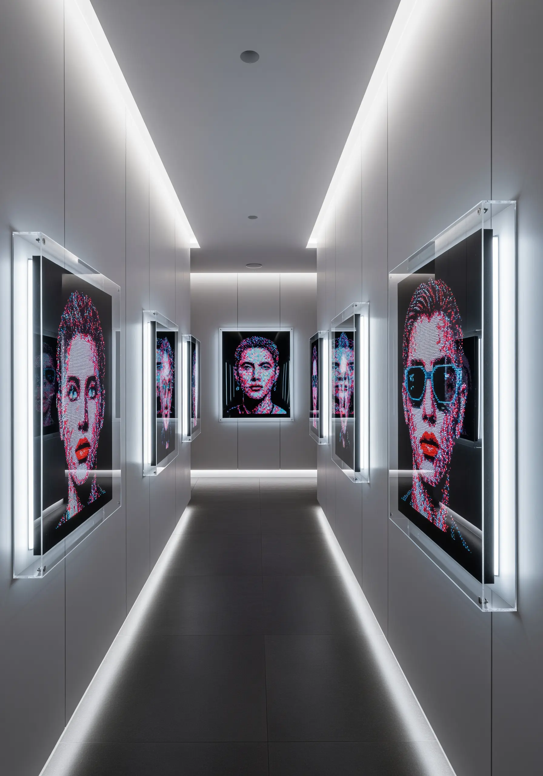 A futuristic white hallway with backlit, pixel-style embroidered portraits in acrylic frames.