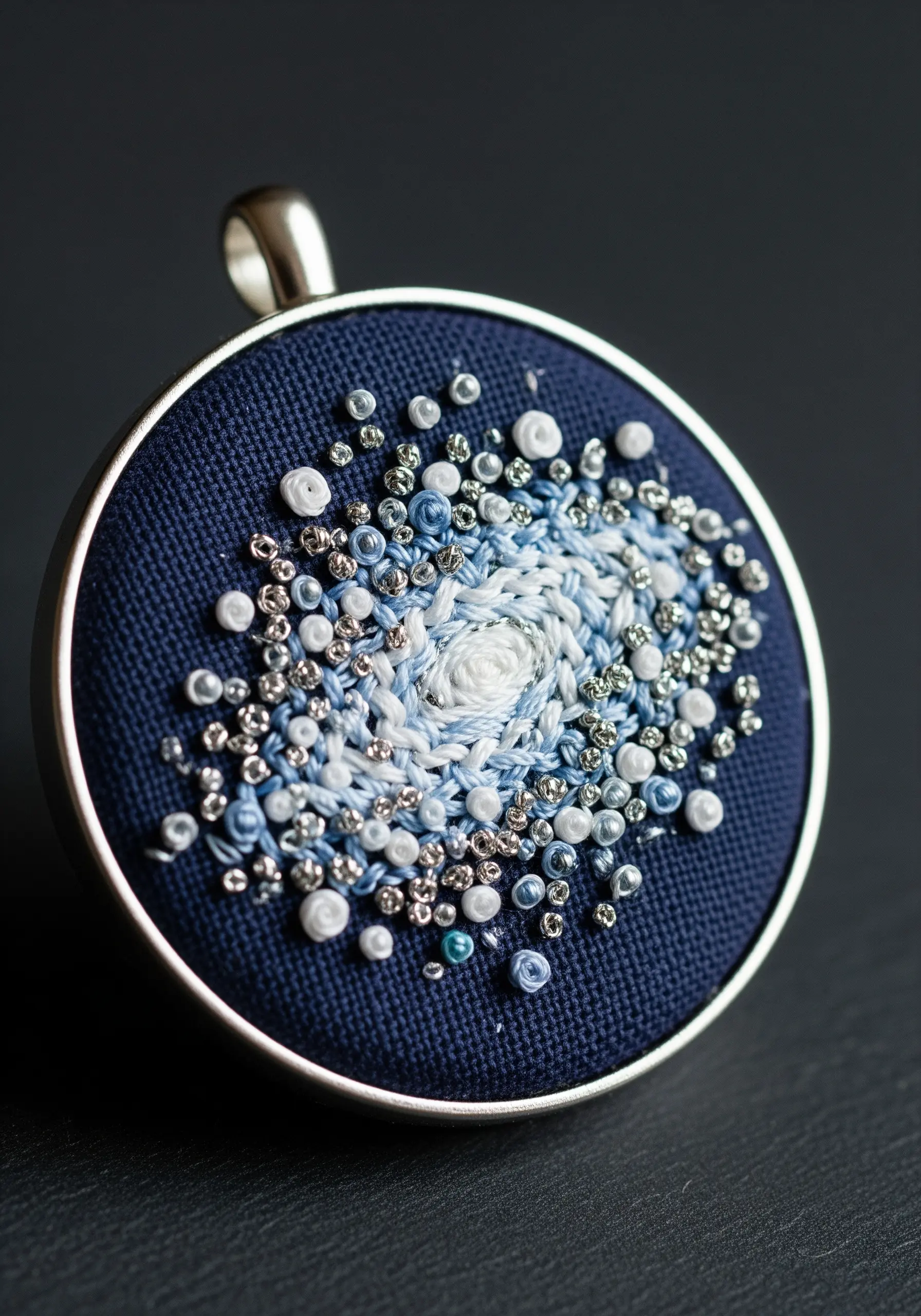 A cosmic swirl of French knots, bullion knots, and beads in a pendant.