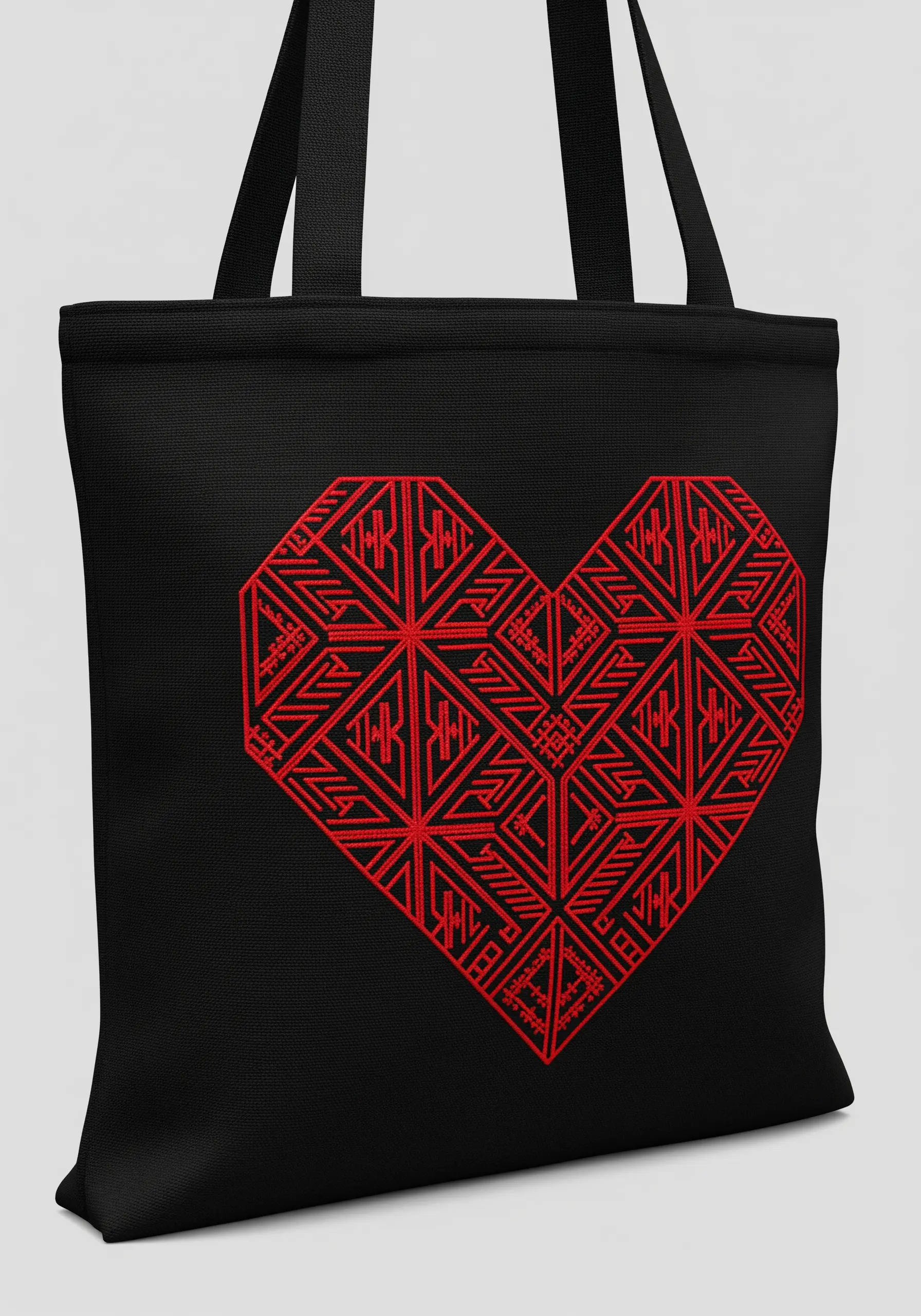 A large heart filled with an intricate red geometric line pattern, embroidered on a black tote bag.