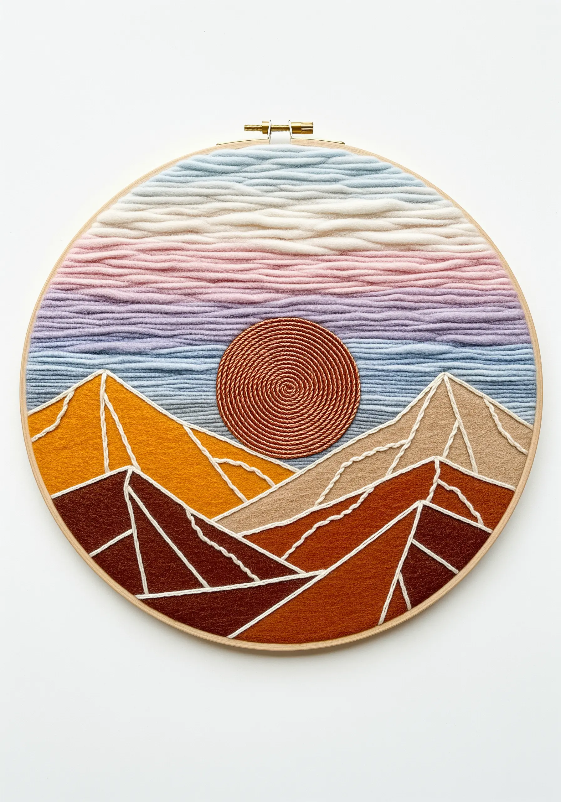 A geometric mountain landscape in a hoop, using yarn for color blocking and a coiled sun.