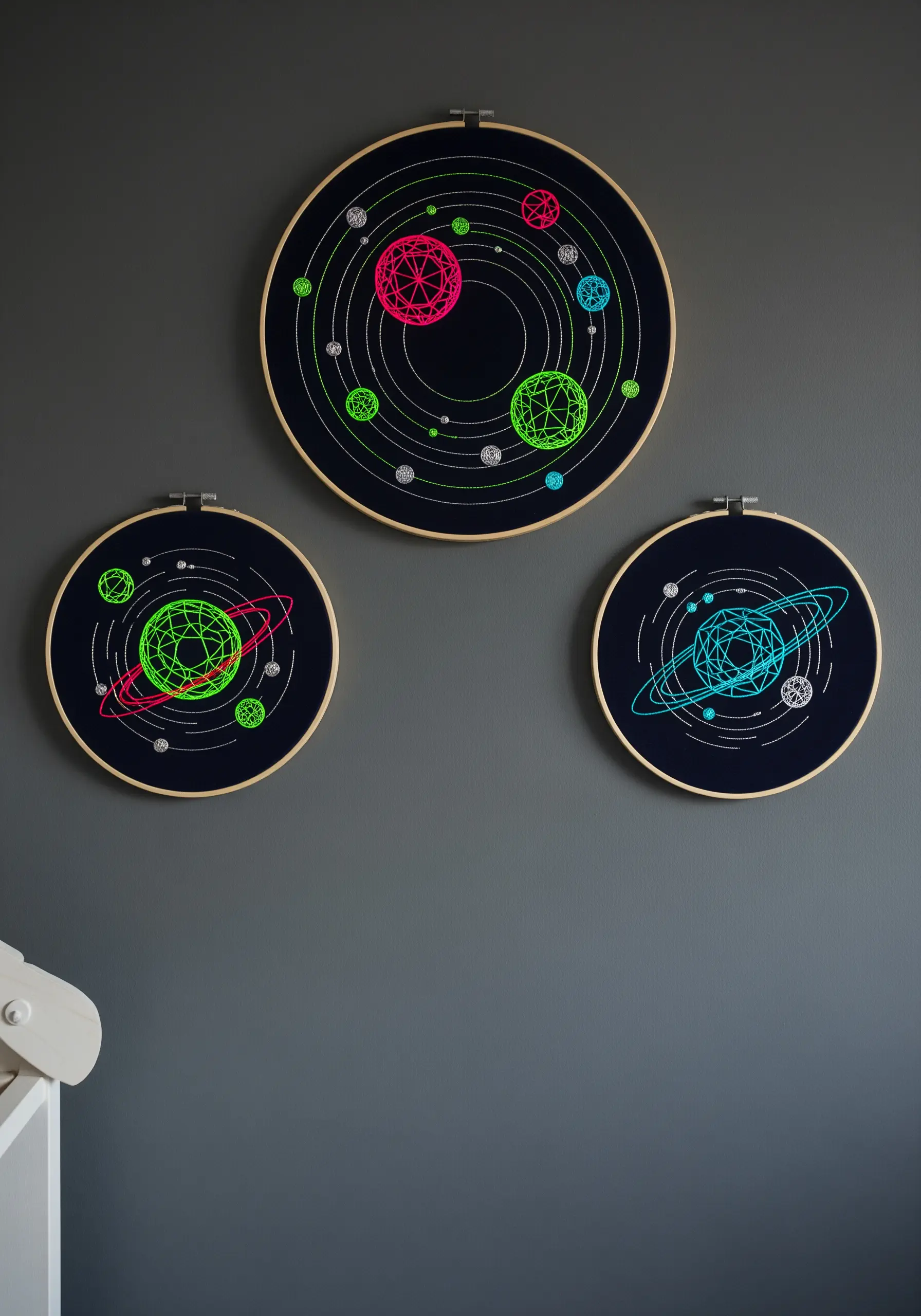 Neon geometric solar system embroidery on black fabric