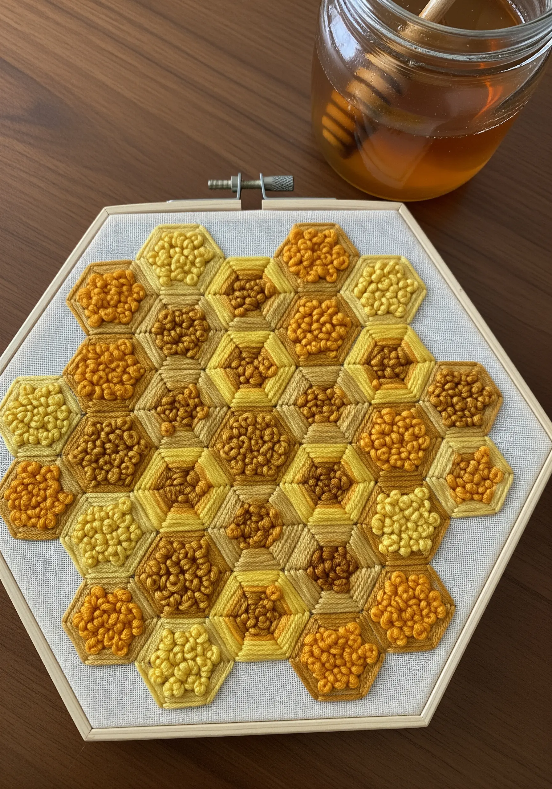 Honeycomb embroidery pattern with yellow and brown French knots and satin stitches.