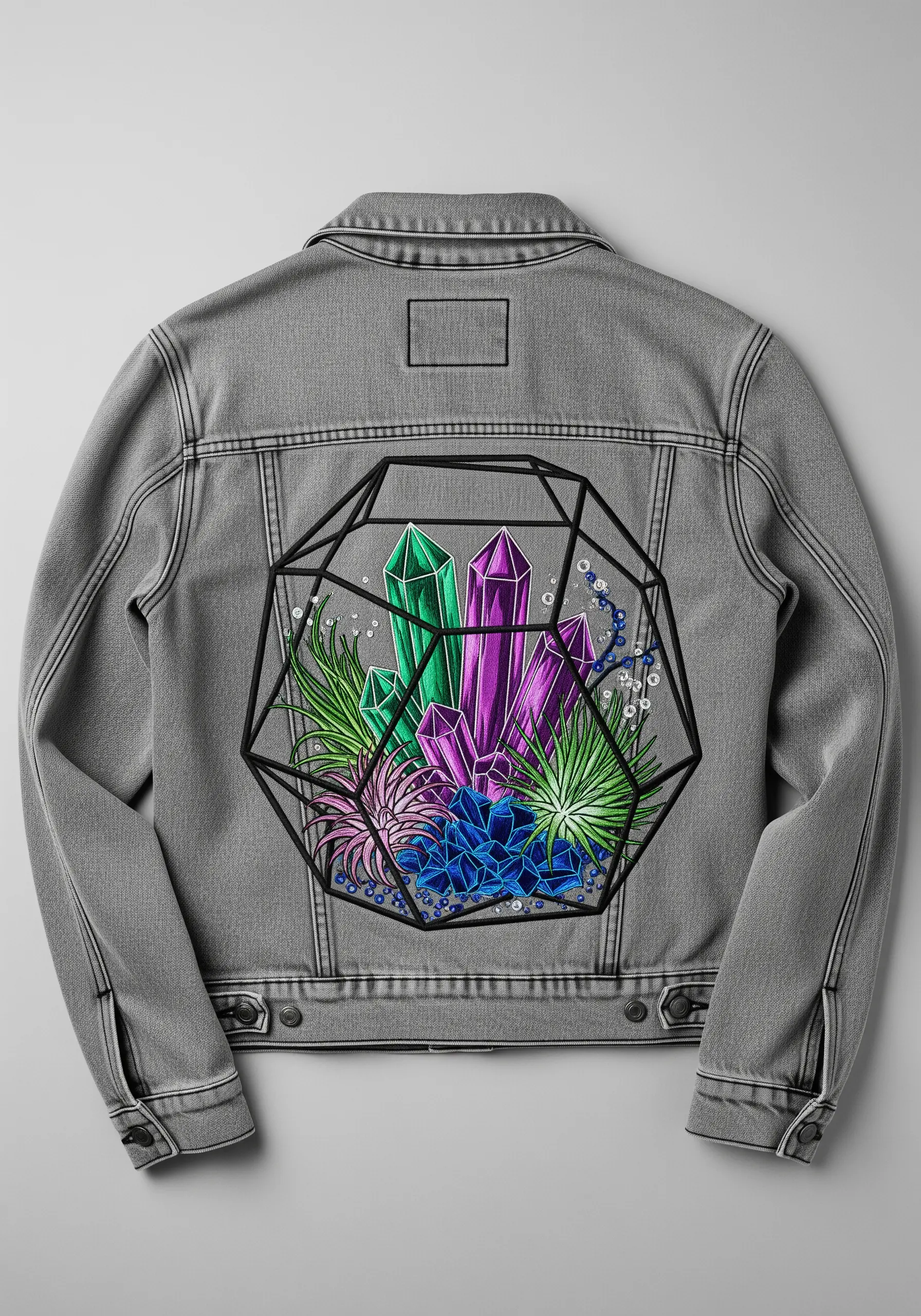 Geometric terrarium with colorful embroidered crystals on a grey denim jacket.