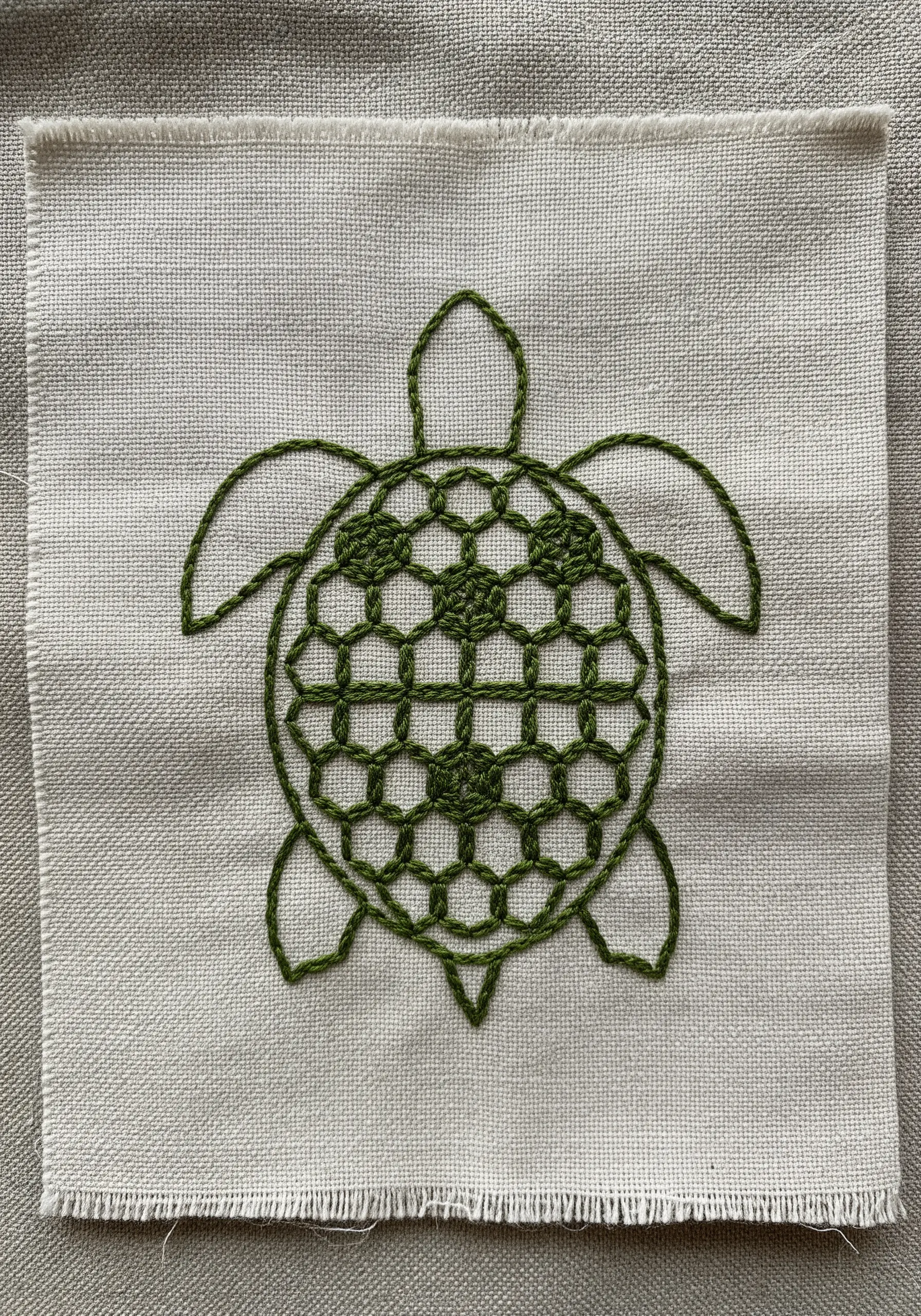 Green geometric turtle embroidery with a hexagonal shell pattern