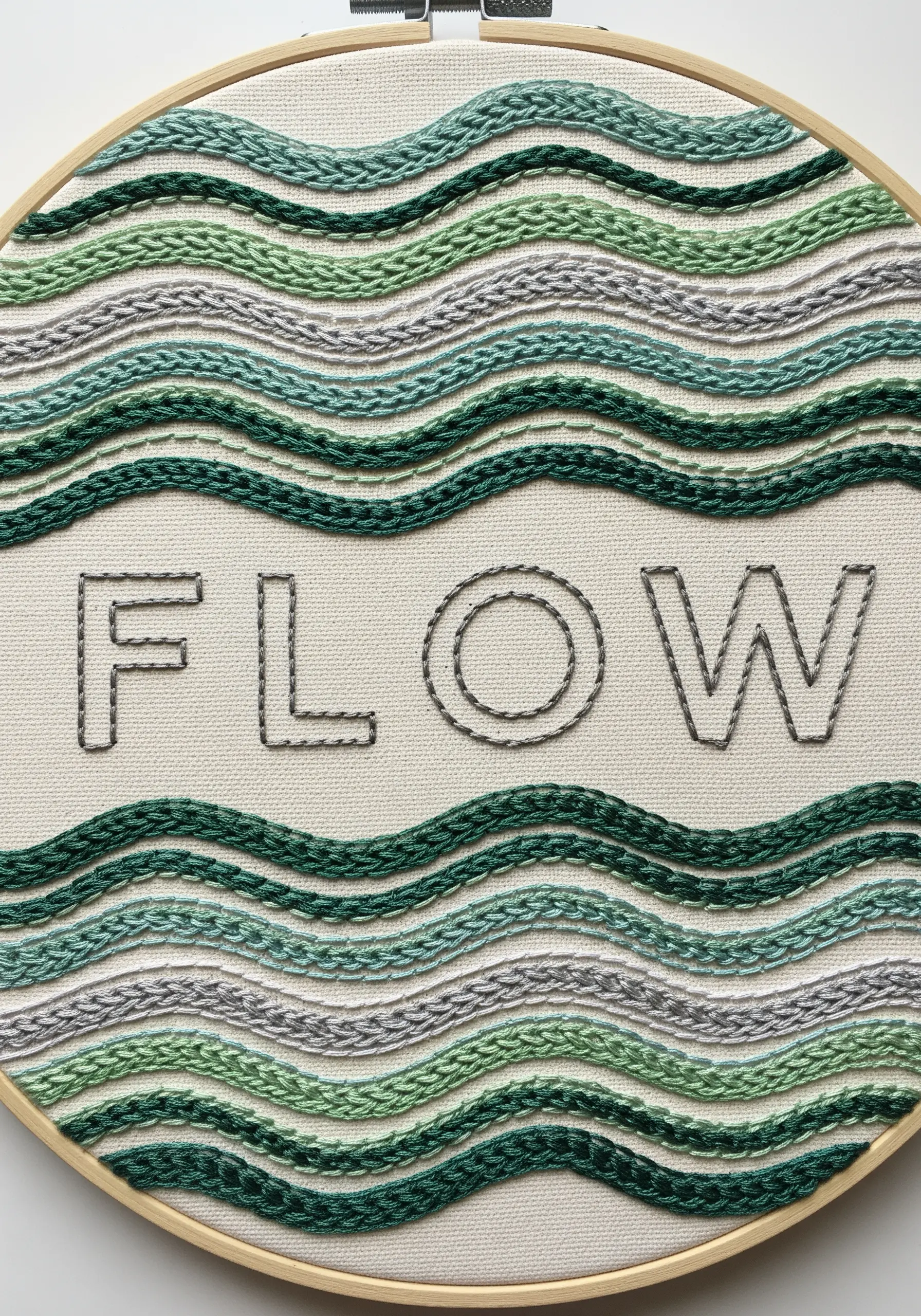 The word FLOW in negative space, surrounded by wavy lines of green and grey textured stitches.