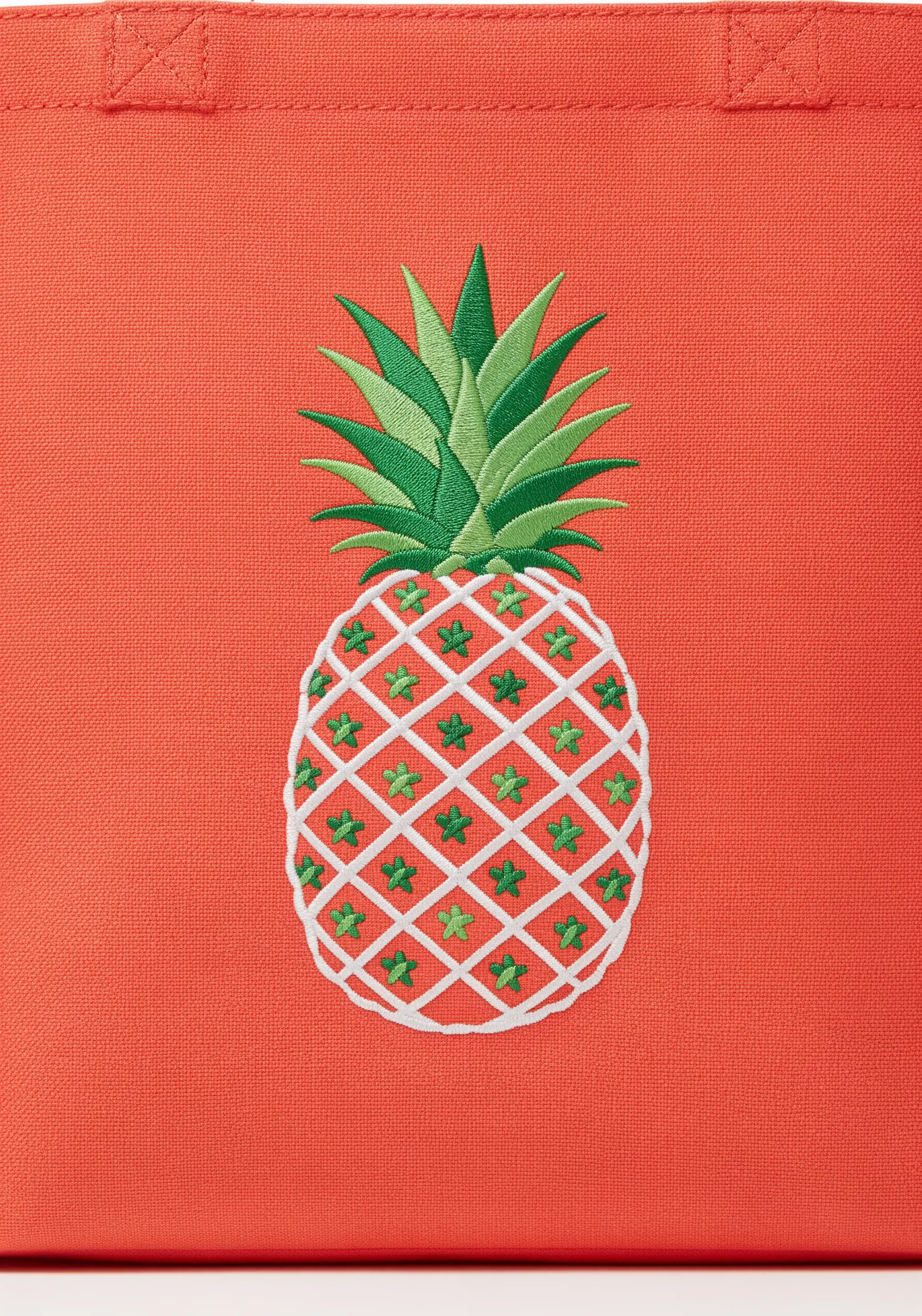 A stylized pineapple with a white lattice pattern on a bright coral tote bag.