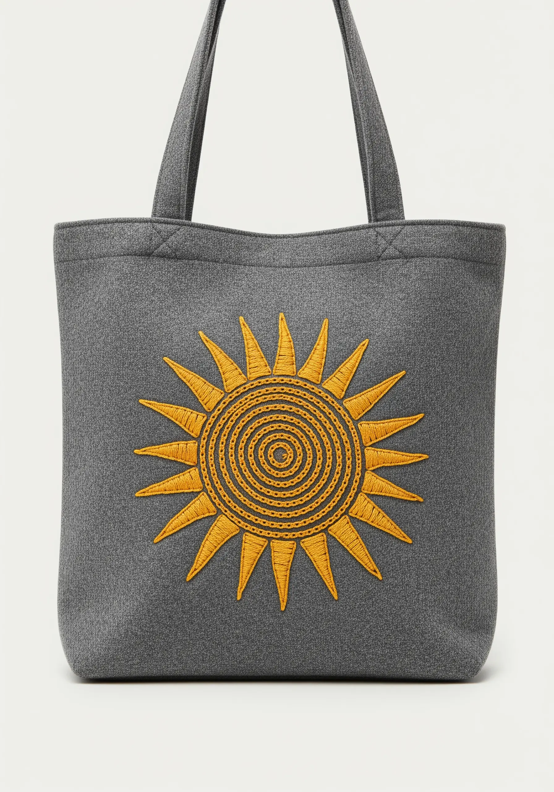 A stylized sun with a spiraled center and sharp rays on a dark gray tote.