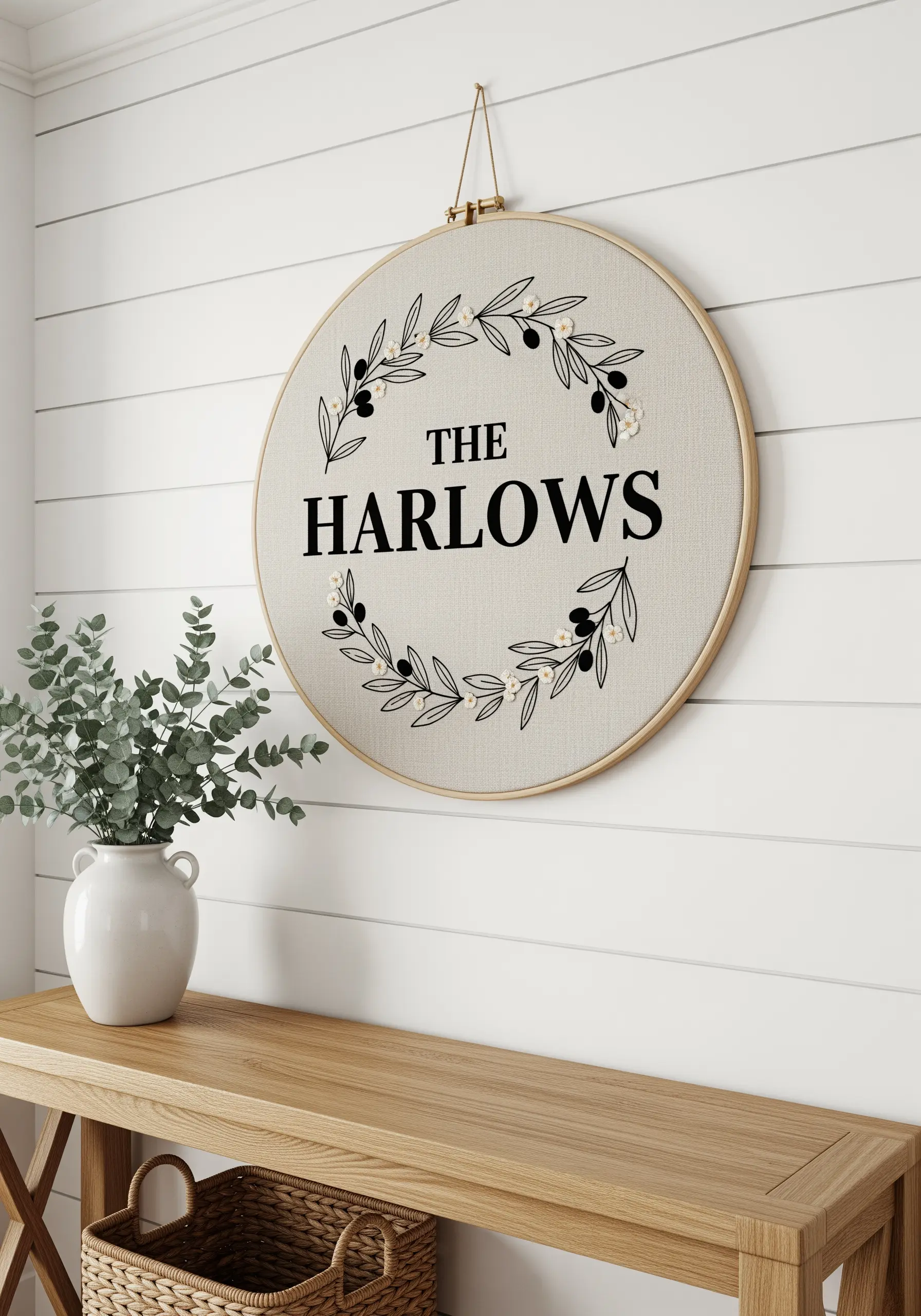 Embroidery hoop with a family name framed by stitched olive branches.