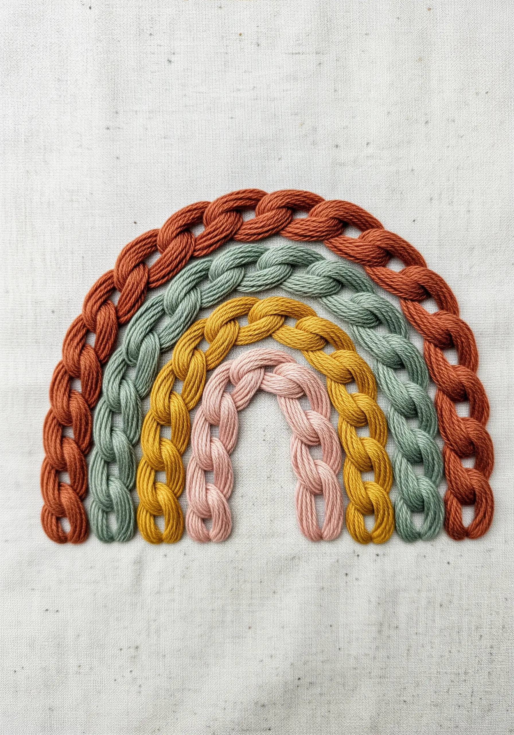 Textured rainbow embroidery using heavy chain stitch in earth tones
