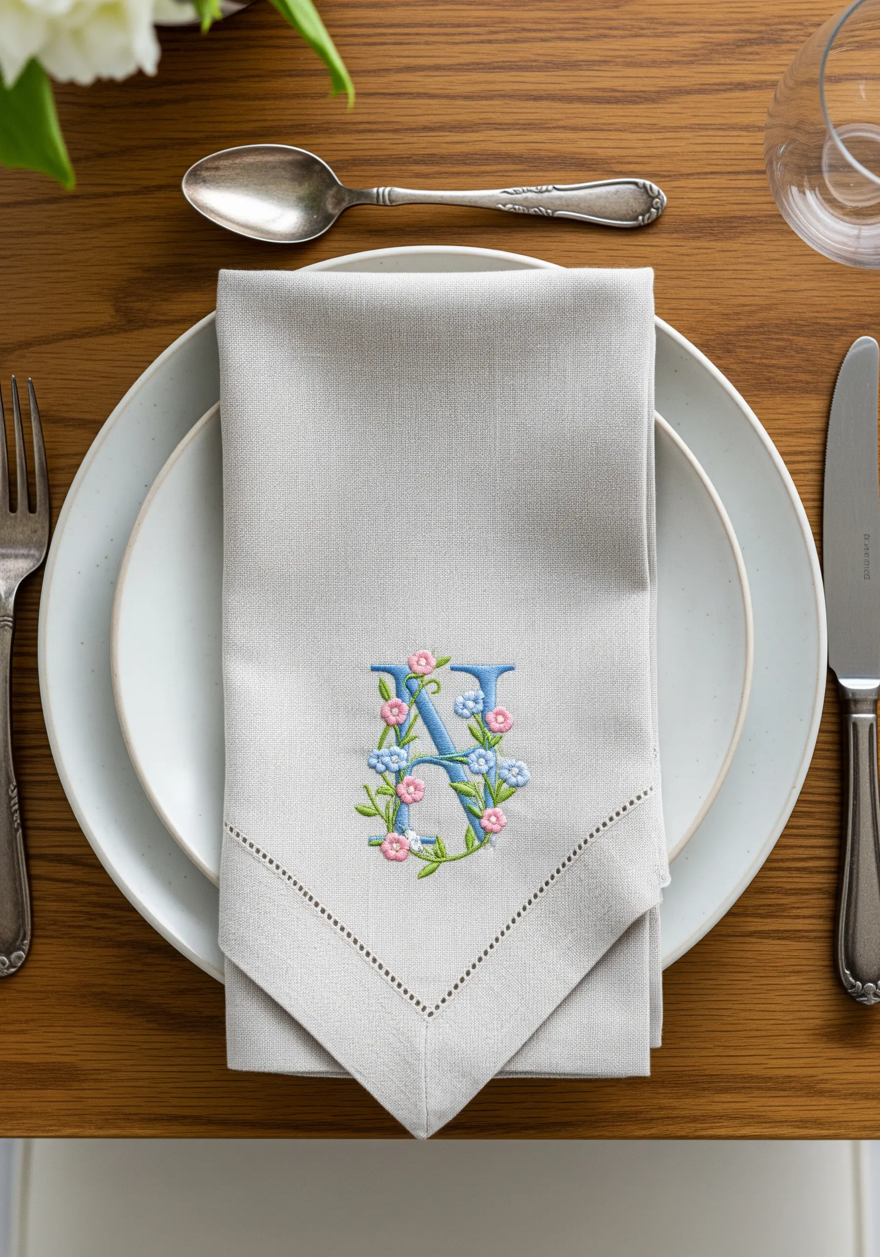 Blue monogram embroidery with floral vines on napkin