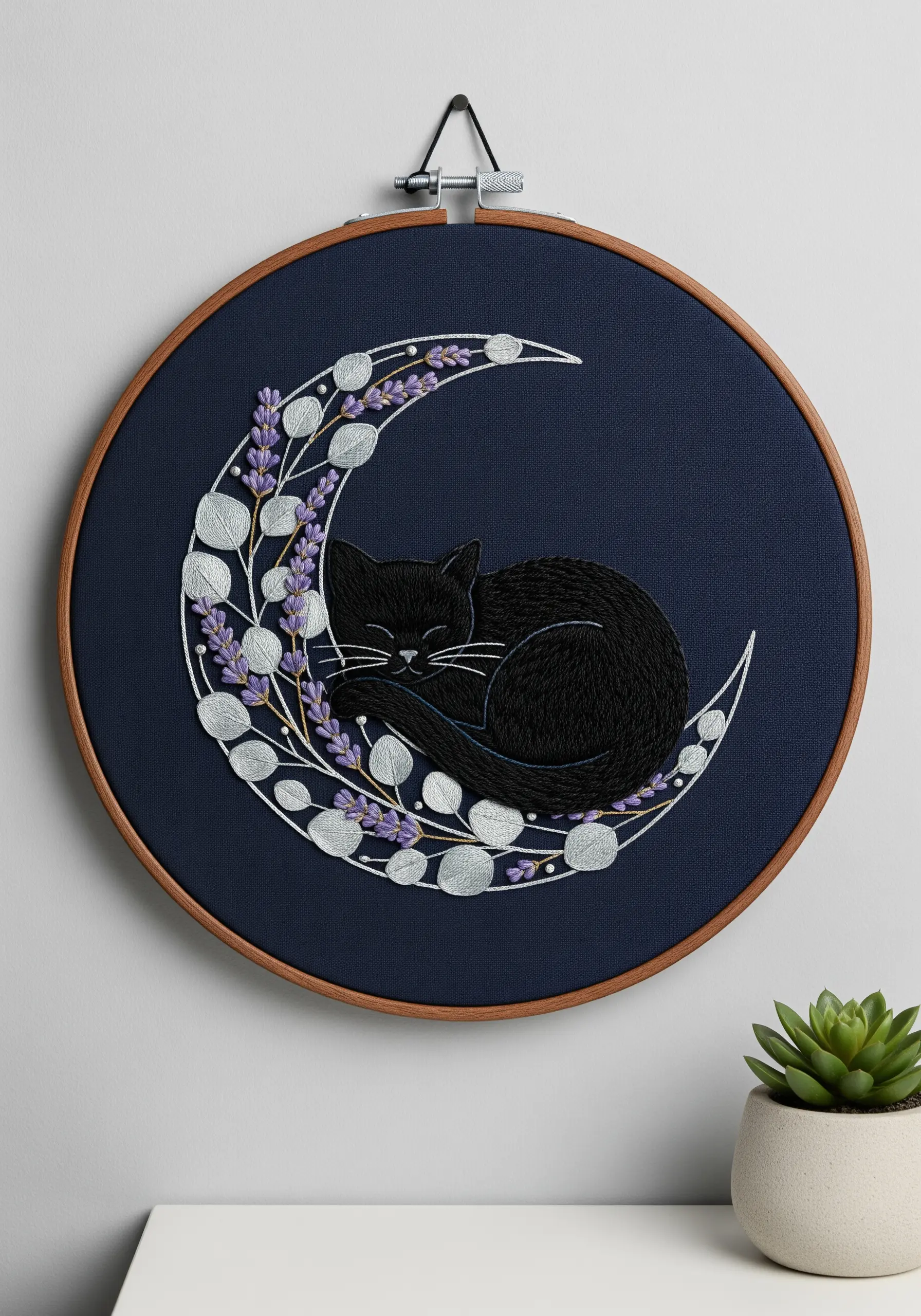 Black cat embroidered on a silver moon with lavender on dark navy fabric.