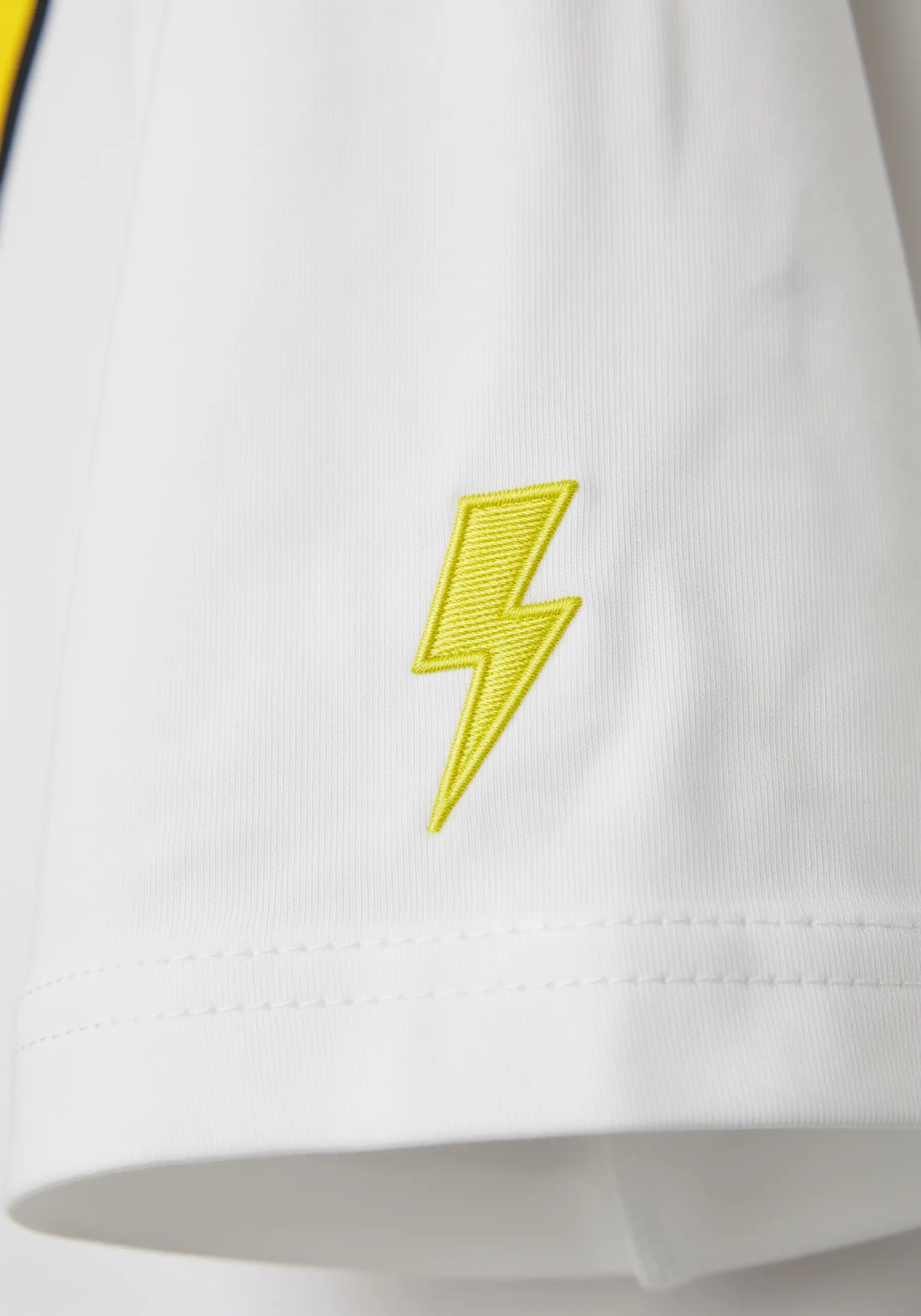 A bright yellow lightning bolt embroidered with a satin stitch on a sleeve.