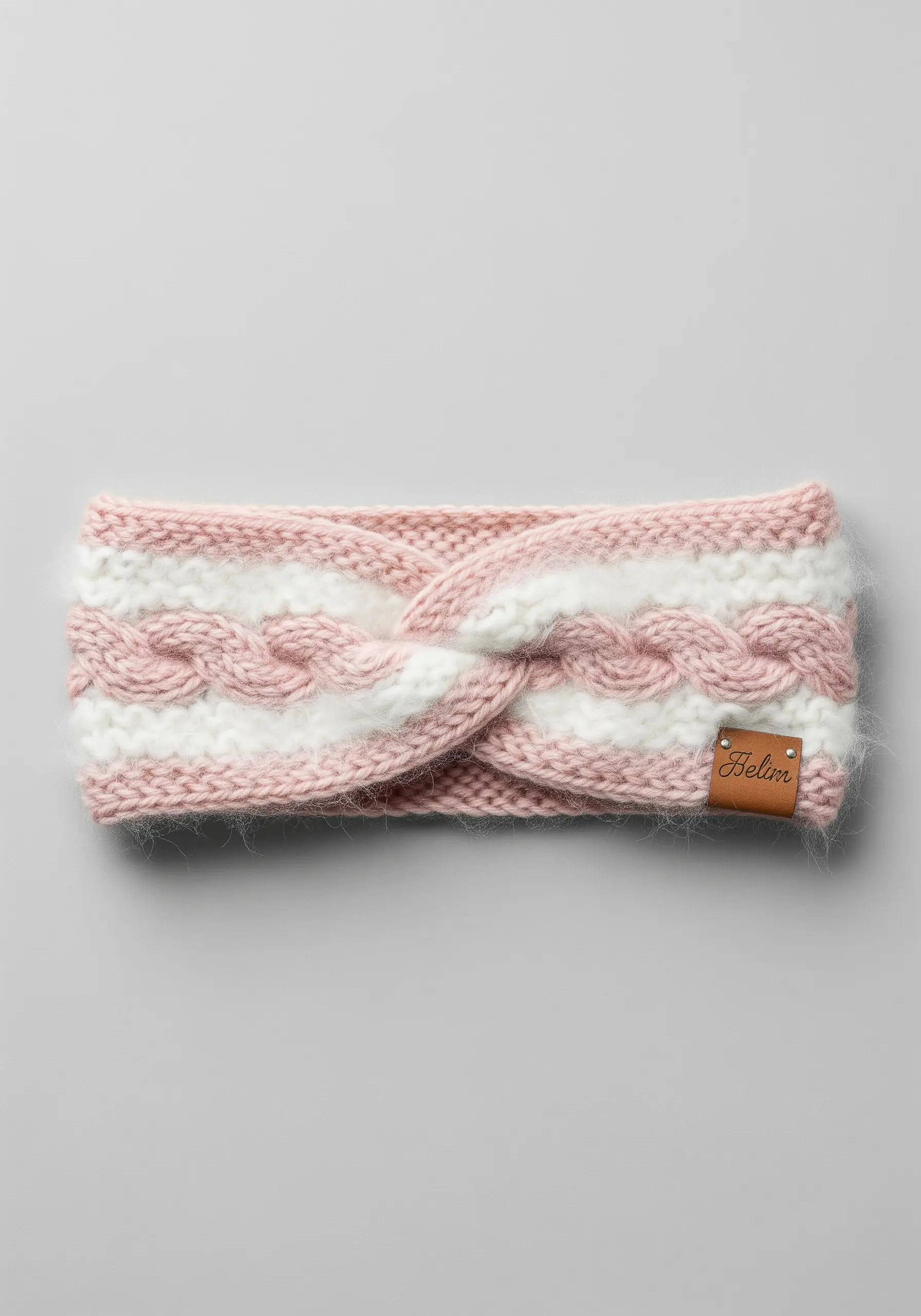 A pink and white knitted headband with a central fluffy white cable knit twist.