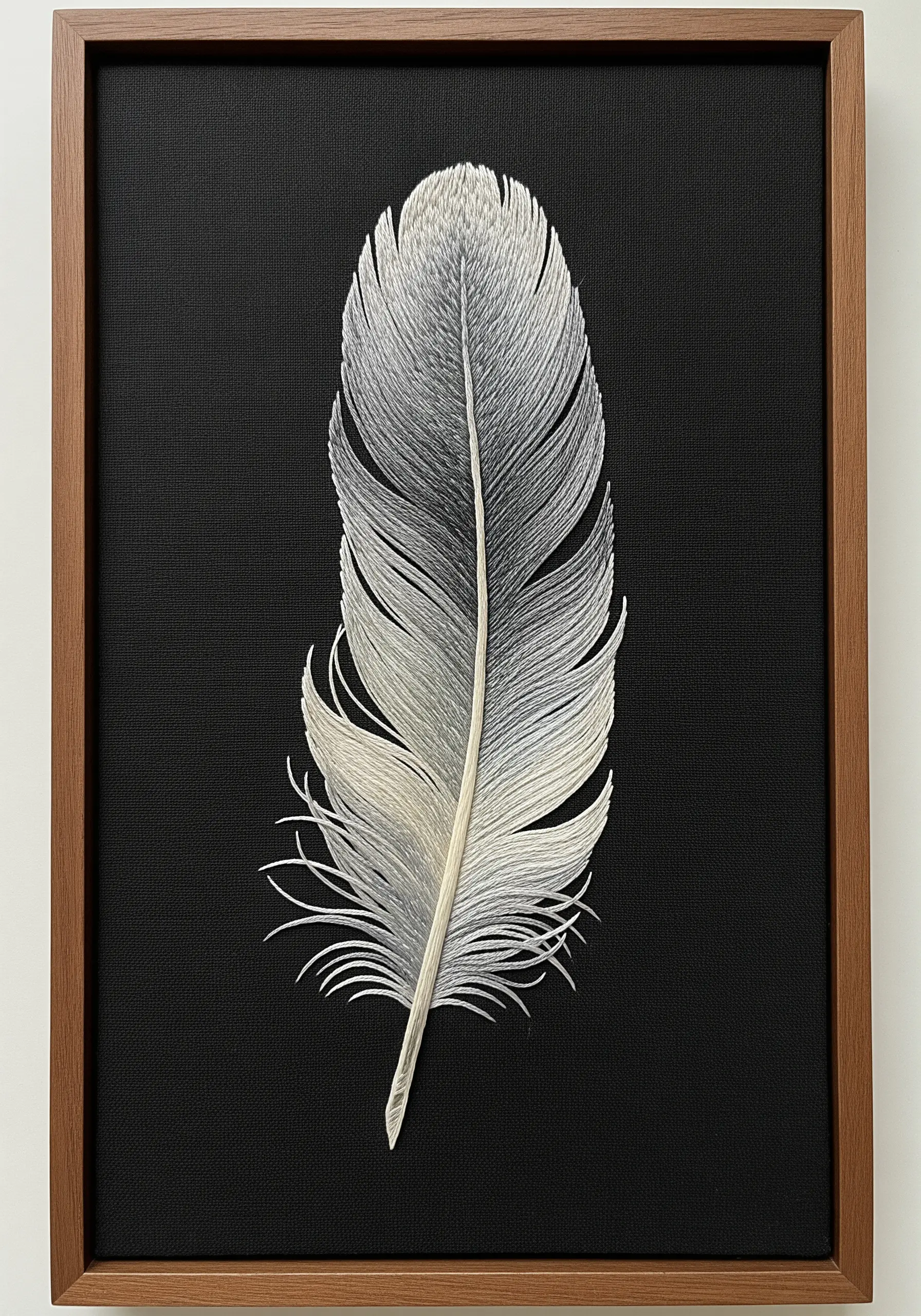 Realistic thread-painted feather in shades of grey and white on black fabric.