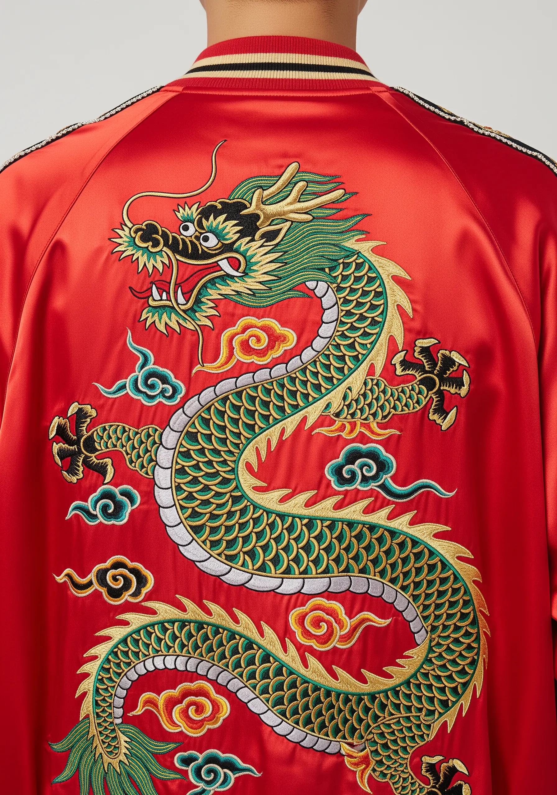 A traditional green and gold Eastern dragon embroidered on the back of a red satin jacket.