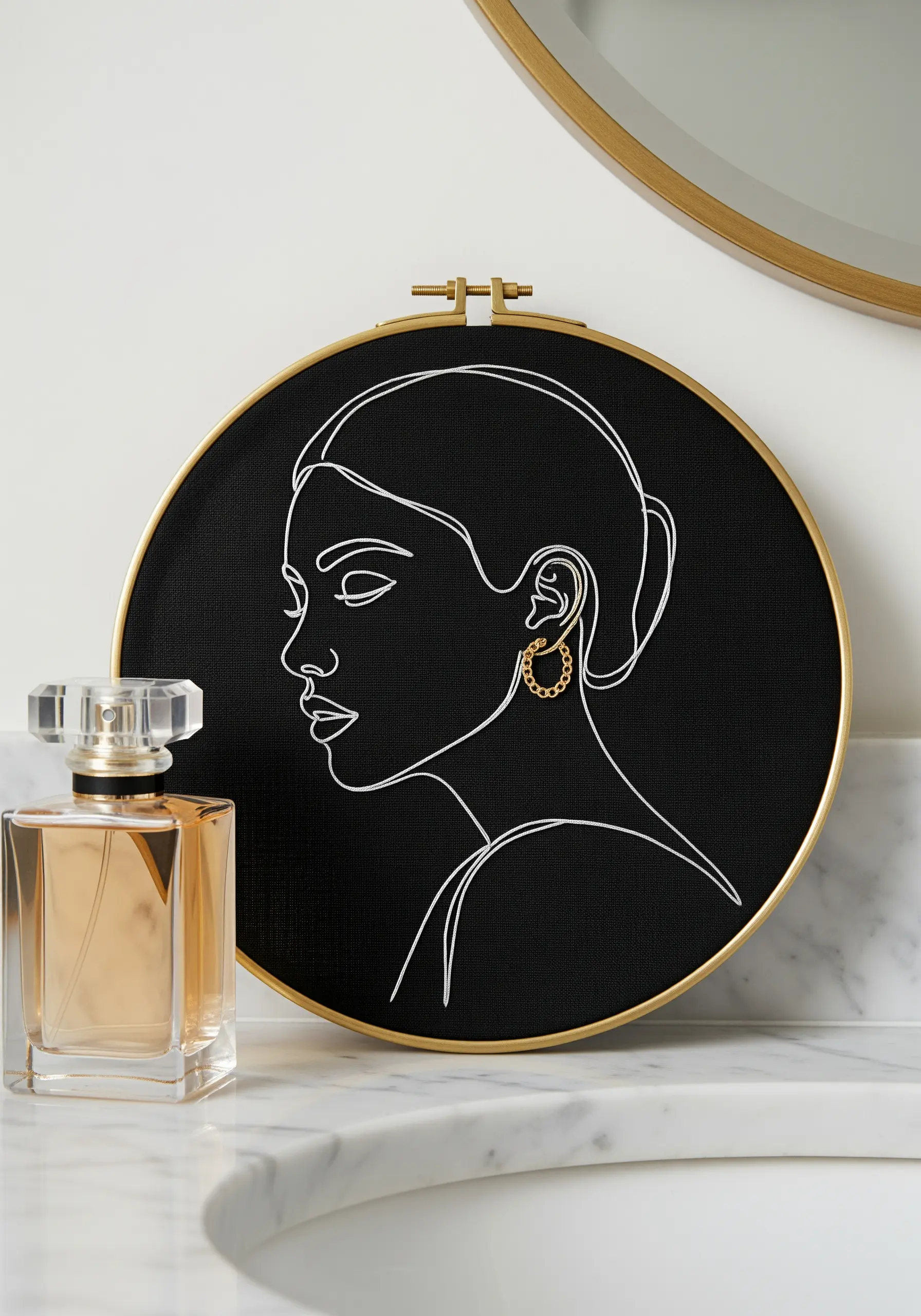 White line-art portrait on black fabric, embellished with a real gold hoop earring.