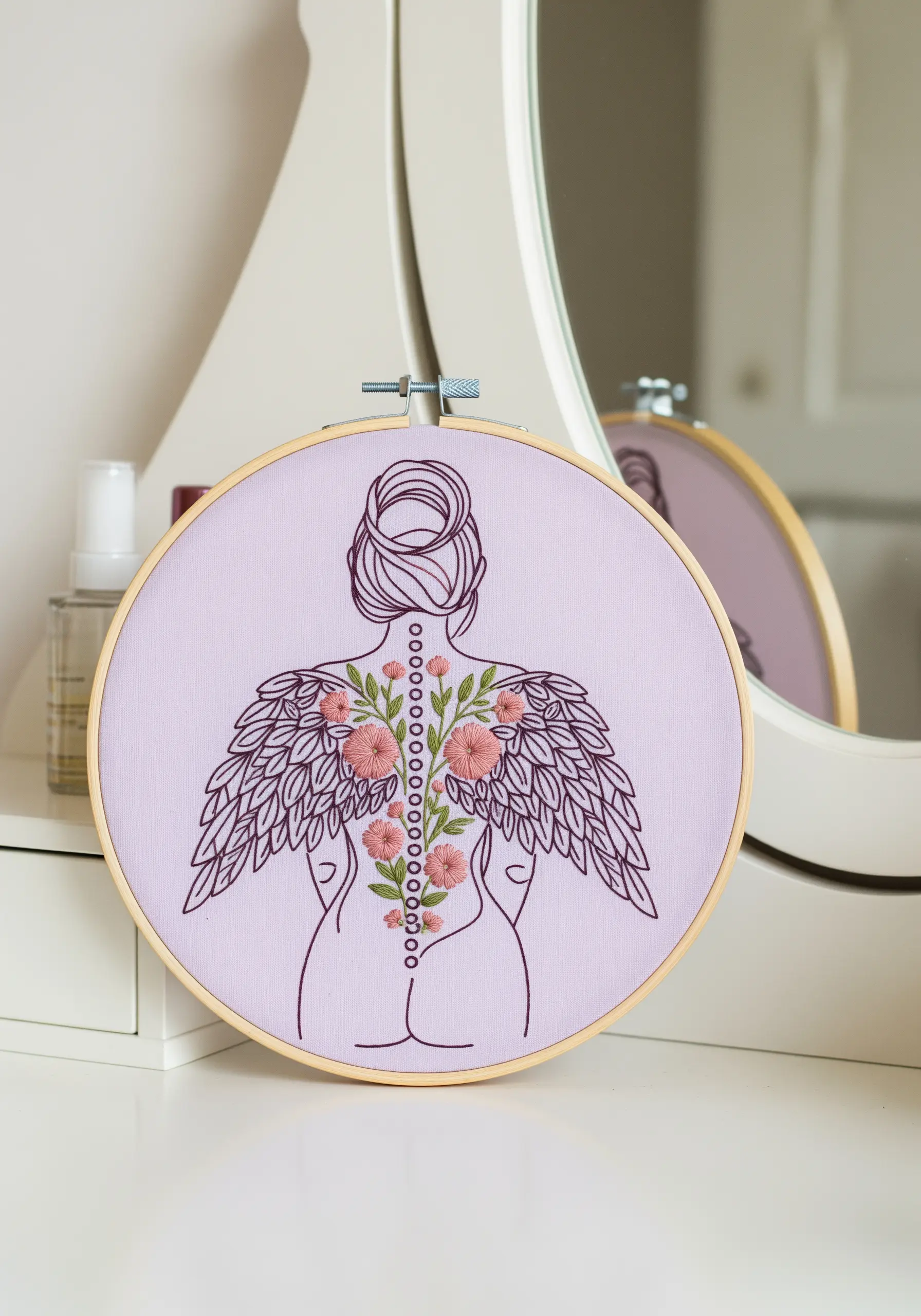 Embroidery of a woman's back with wings, with flowers growing along her spine.