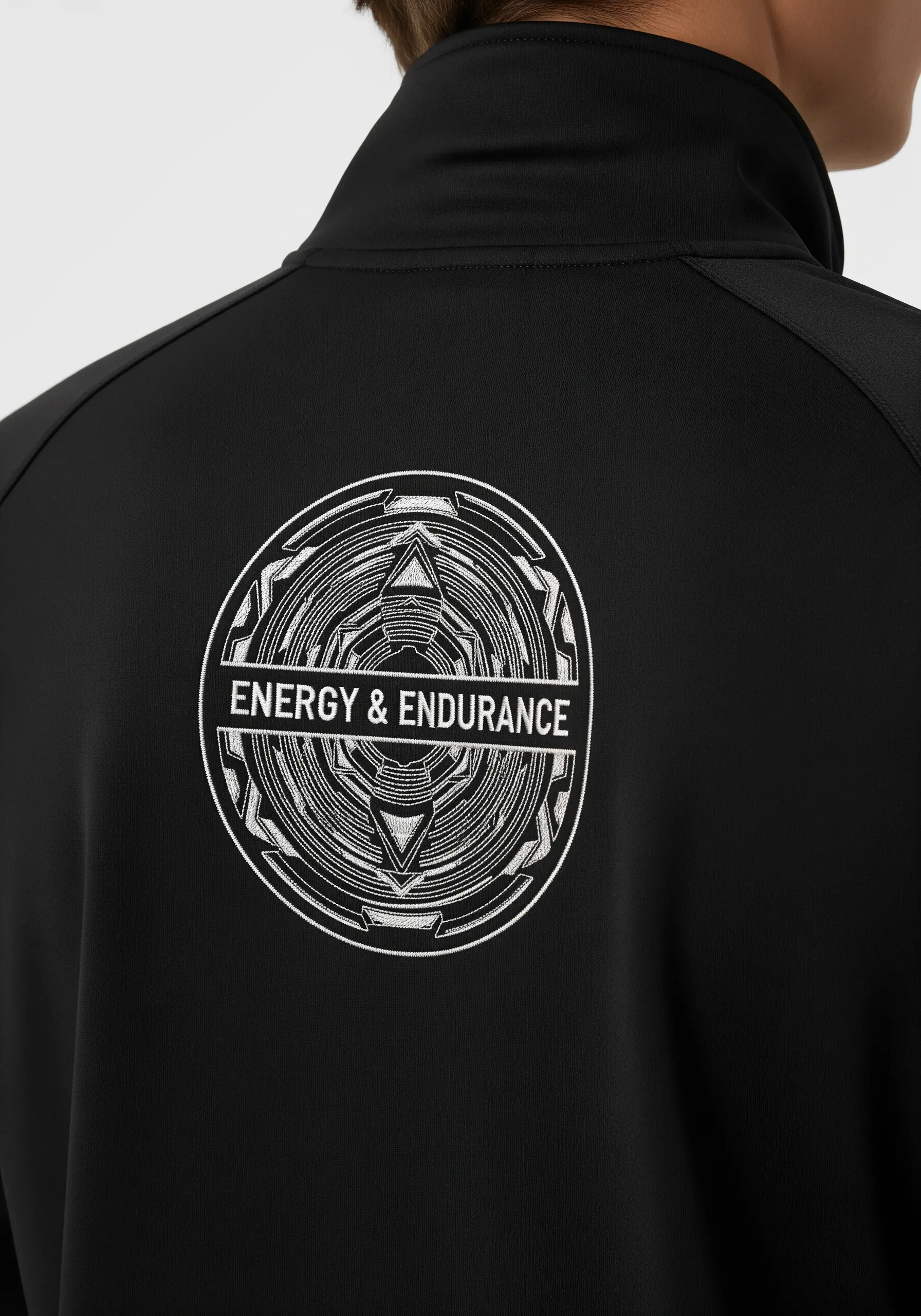 “ENERGY & ENDURANCE” inside a futuristic geometric circle embroidered on a black jacket.