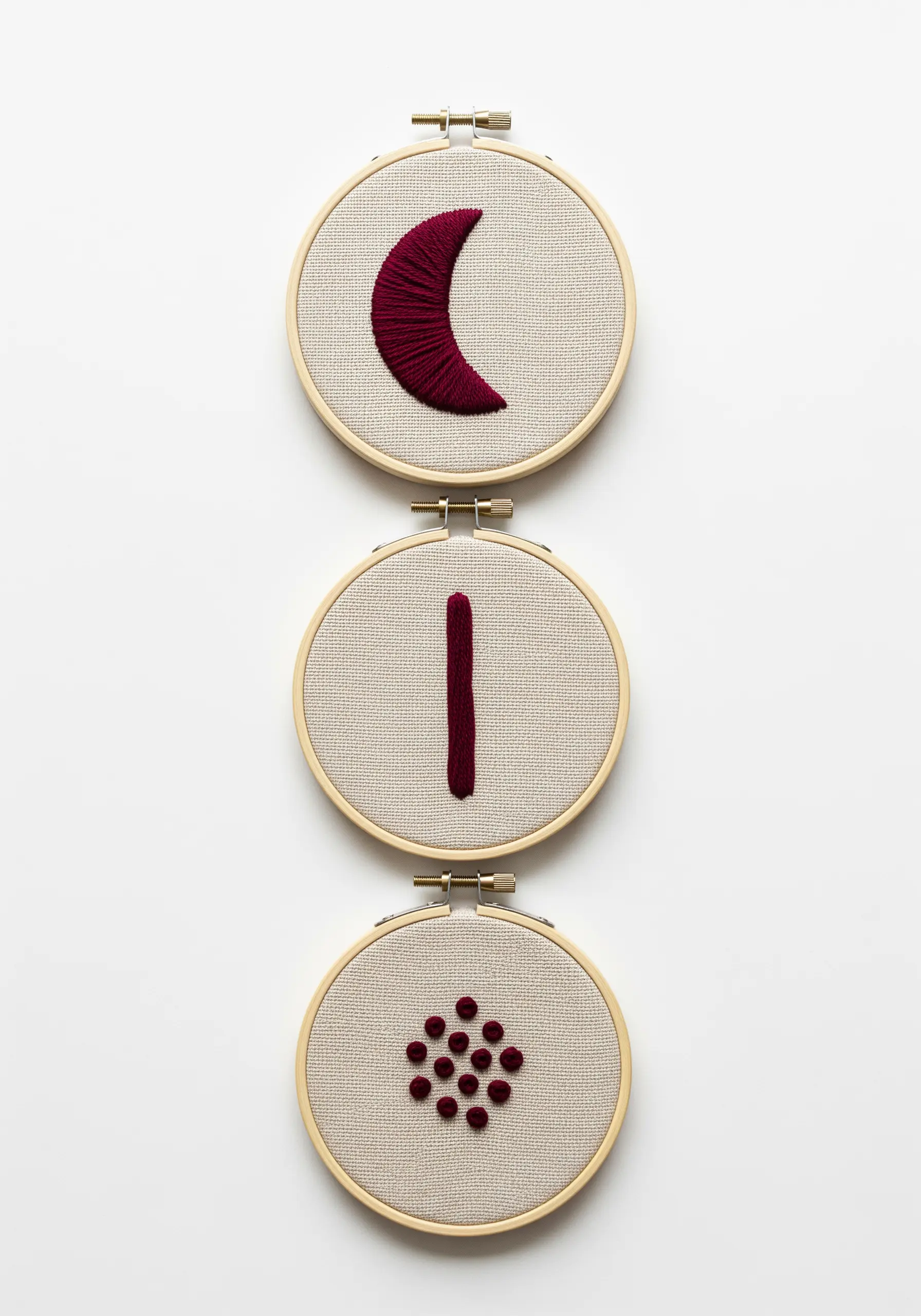 Three small hoops displaying simple, isolated shapes in deep red thread.
