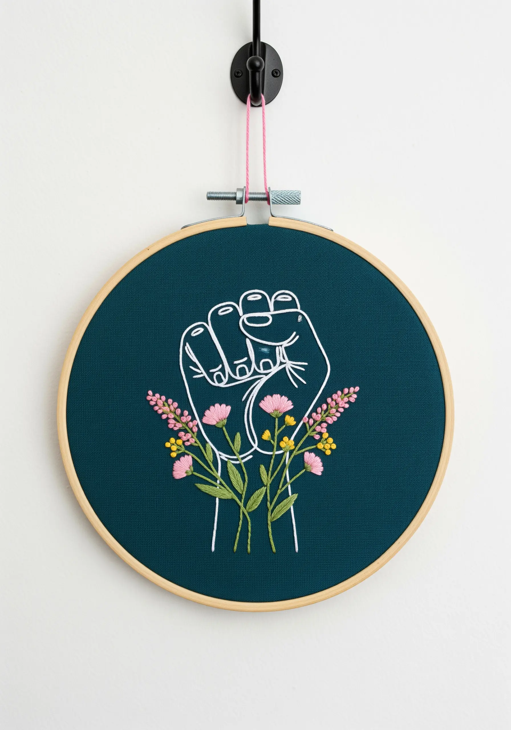 A white line art fist holding a bouquet of delicate pink and yellow embroidered flowers.