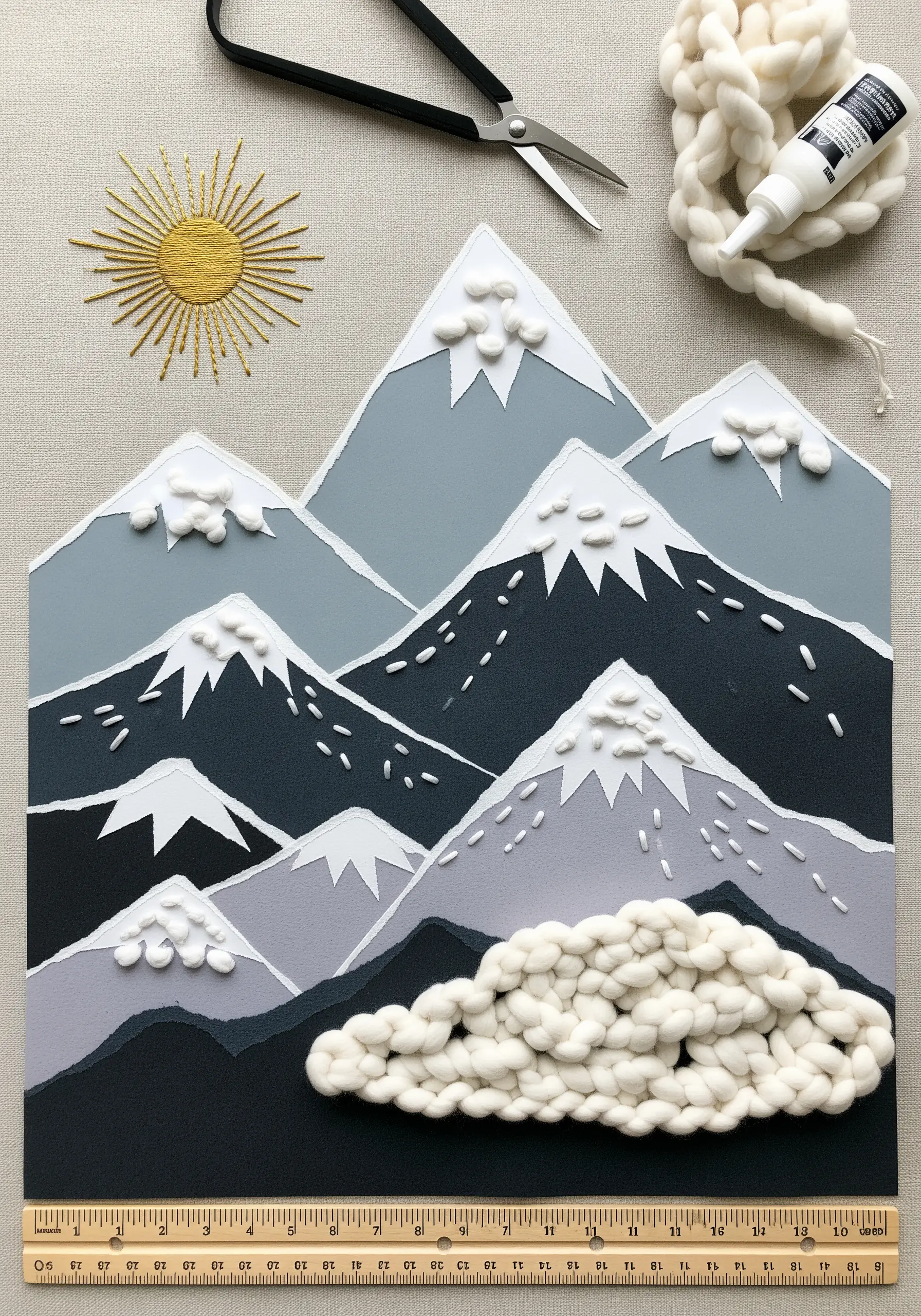 Mixed-media mountain landscape with torn paper, chunky yarn for clouds, and an embroidered sun.