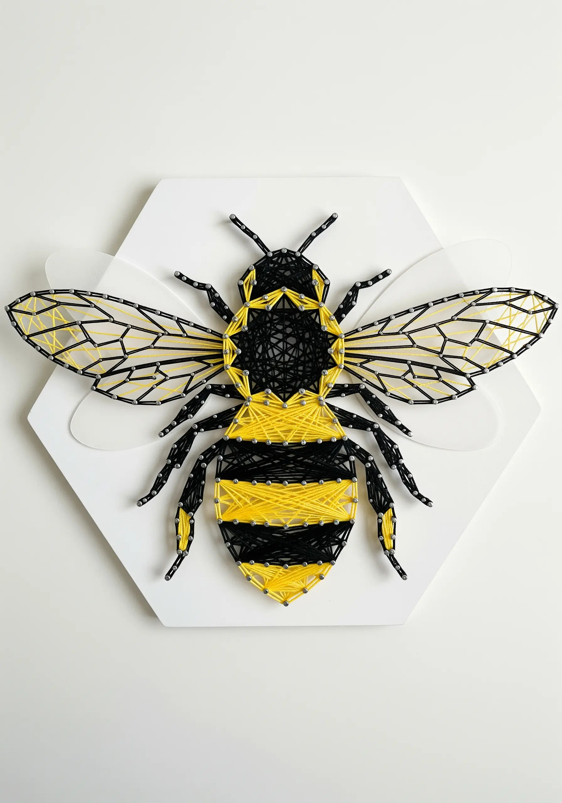 A realistic bee embroidery with sheer organza wings layered over the fabric.