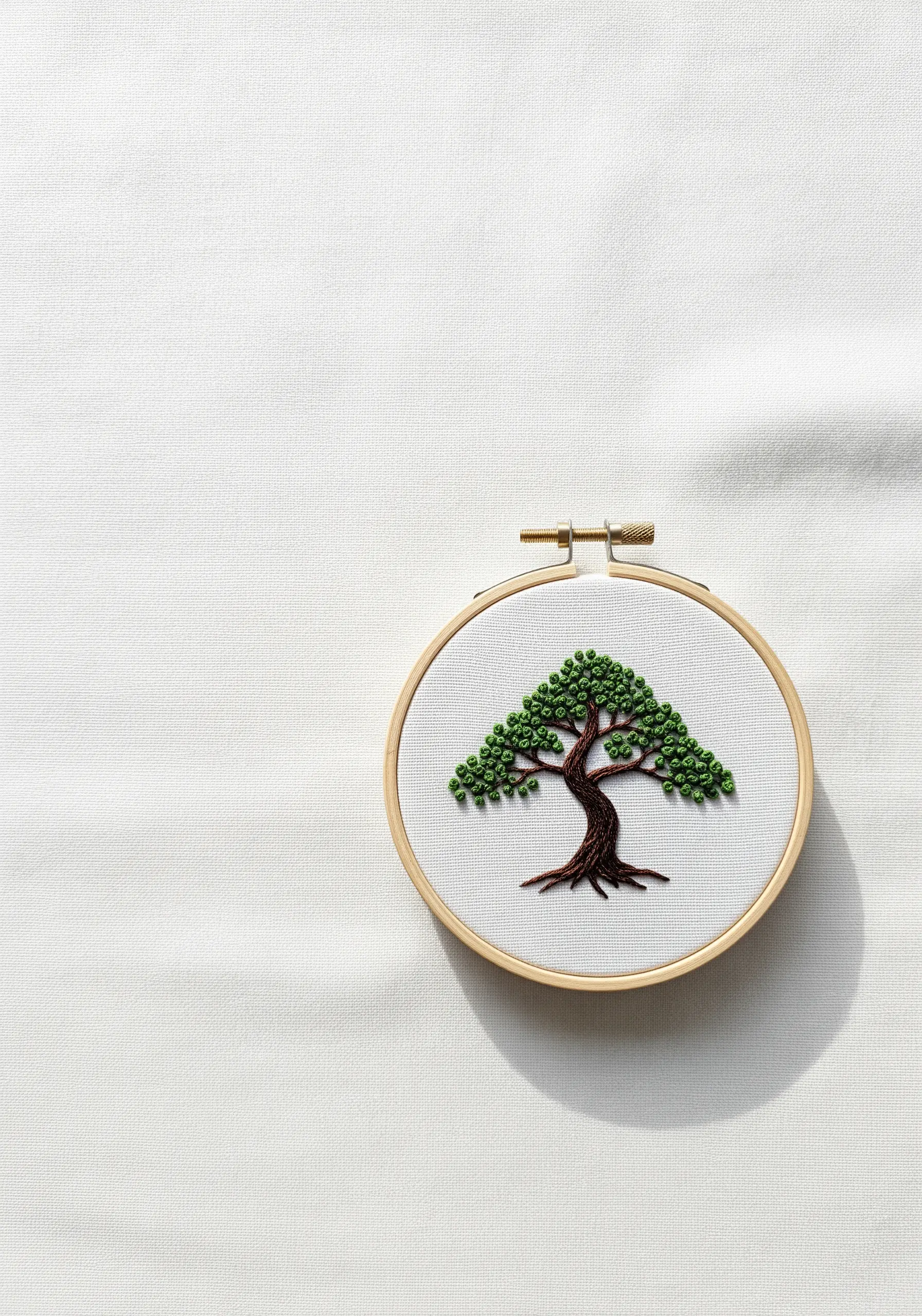 An embroidered bonsai tree with a dense canopy of green French knots.