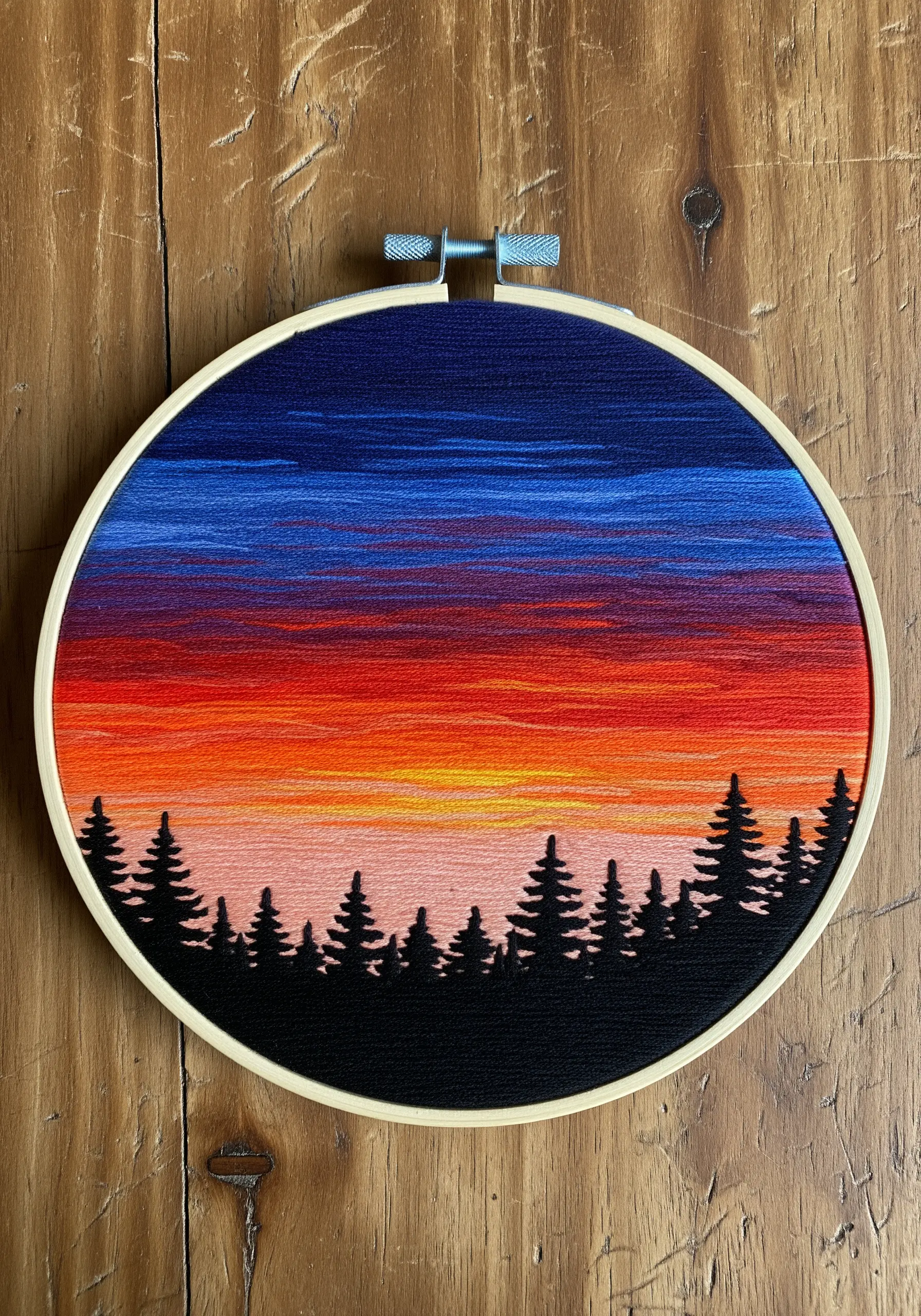 Satin stitch sunset gradient embroidery with silhouette trees