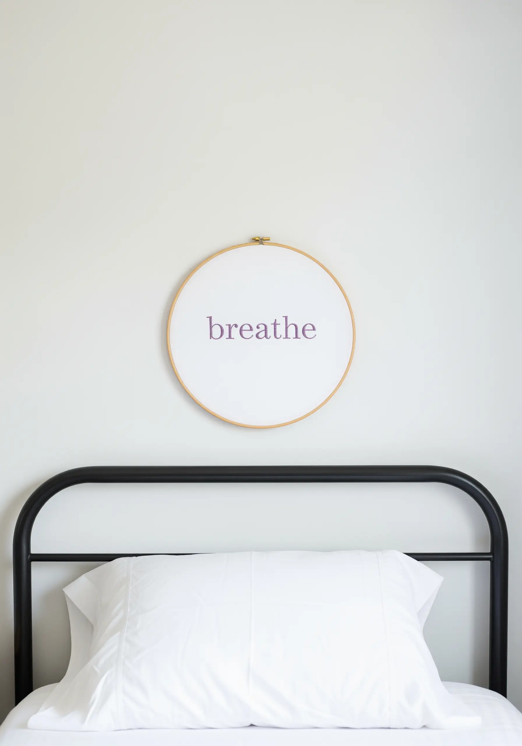 The word 'breathe' embroidered in a simple purple font in the center of a hoop.