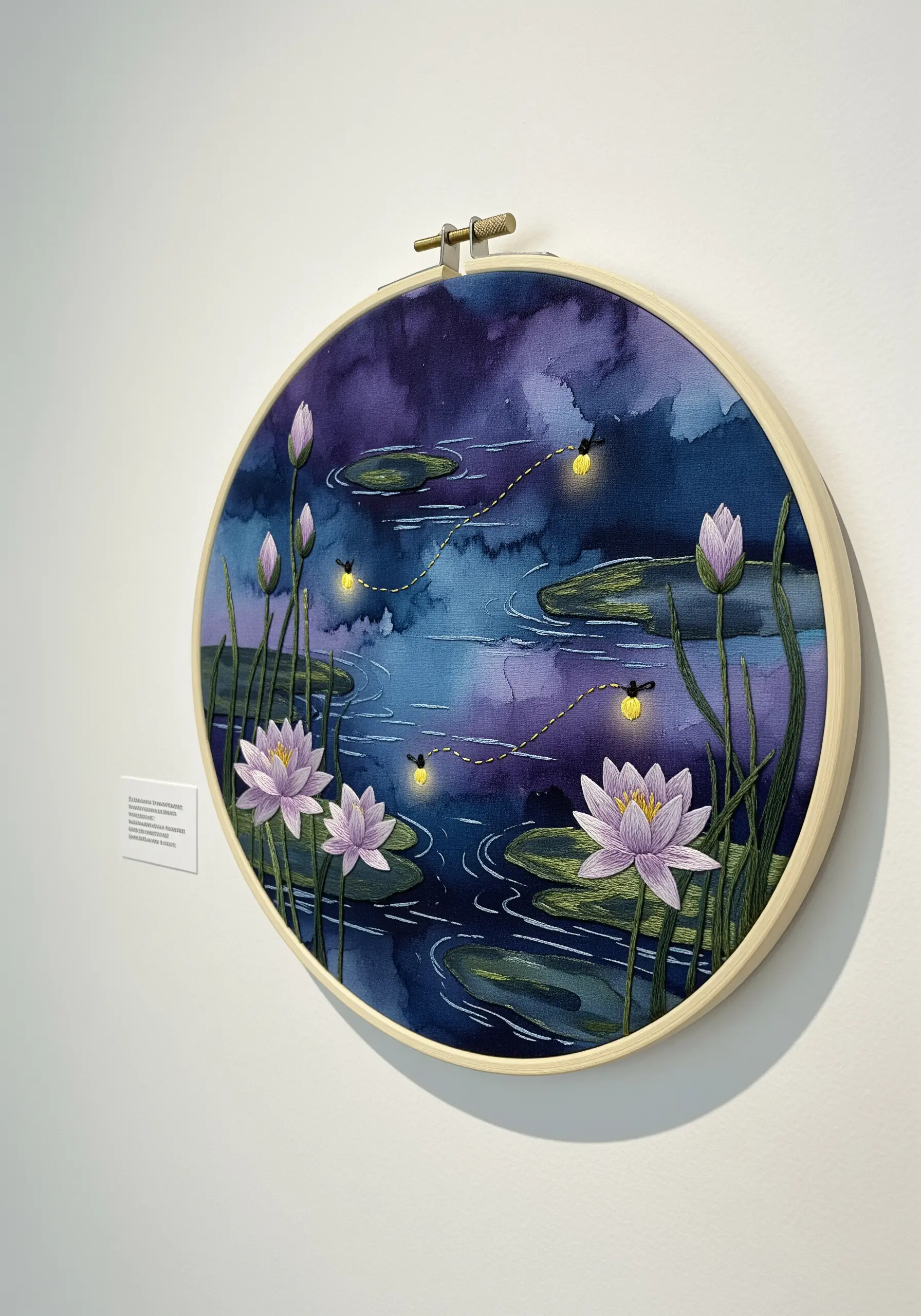 Embroidered water lilies and fireflies on a watercolor-painted fabric background.