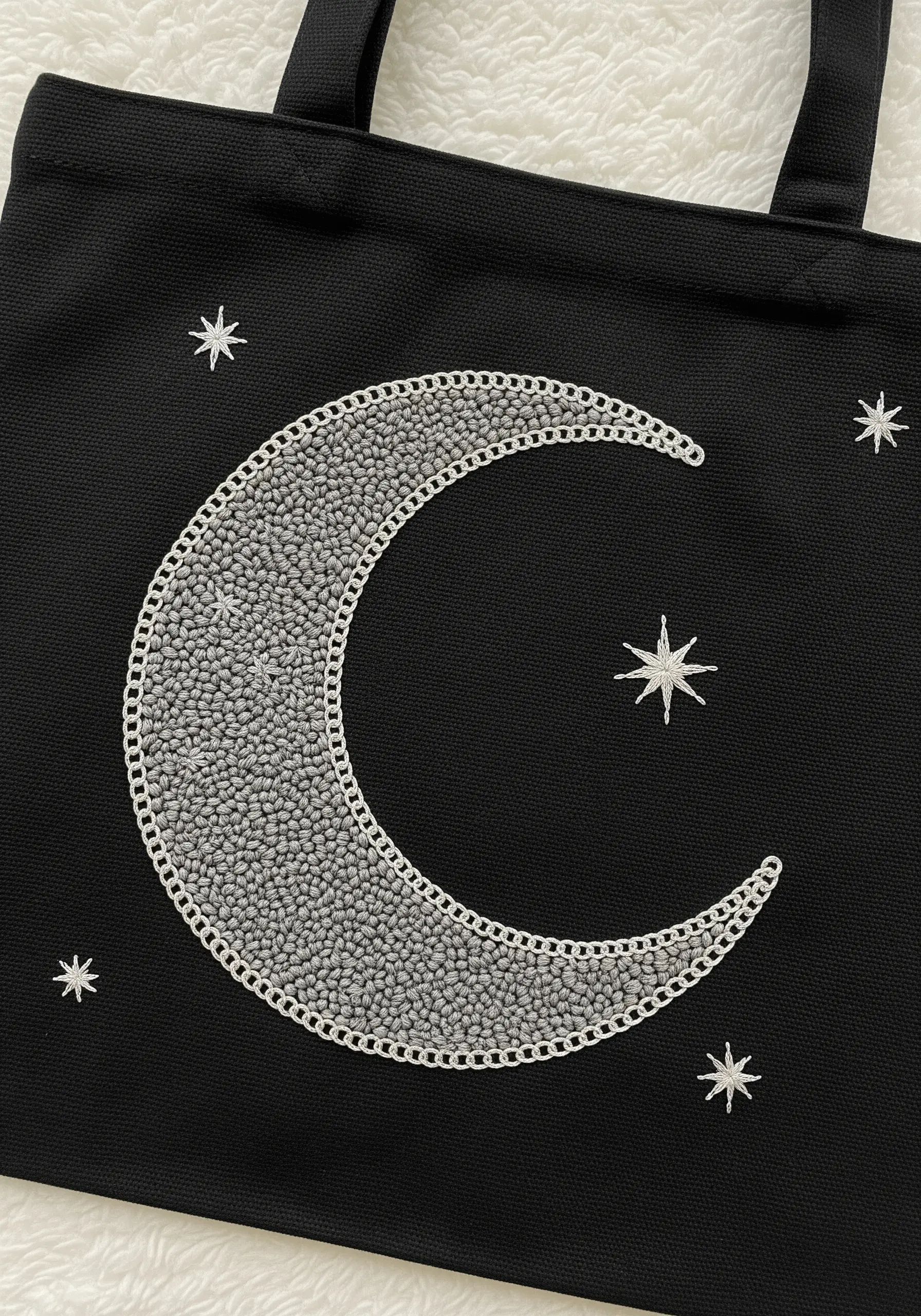 A crescent moon filled with silver seed beads and outlined in silver thread.