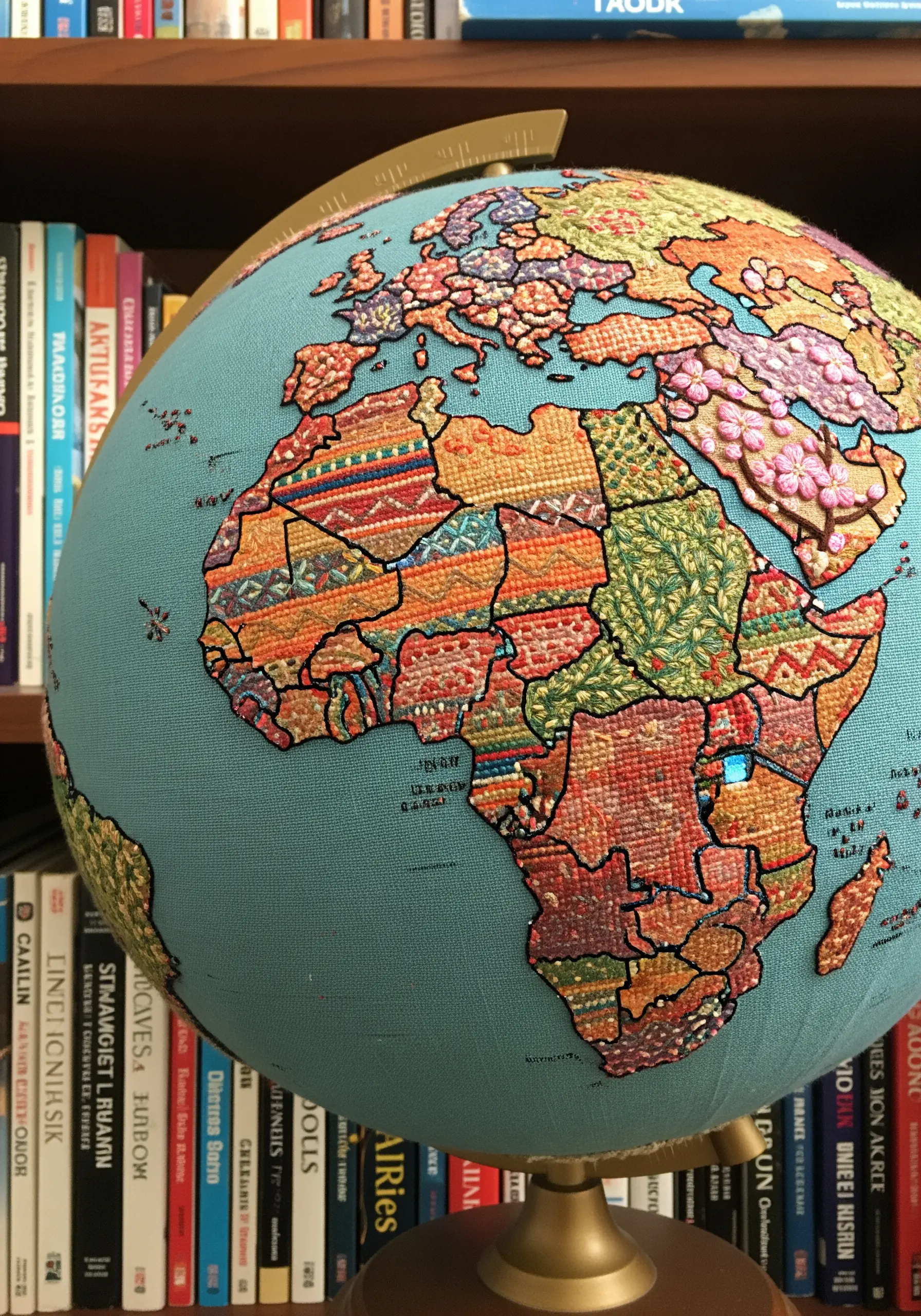 A globe with its continents and countries covered in diverse, colorful embroidered fabric patches.