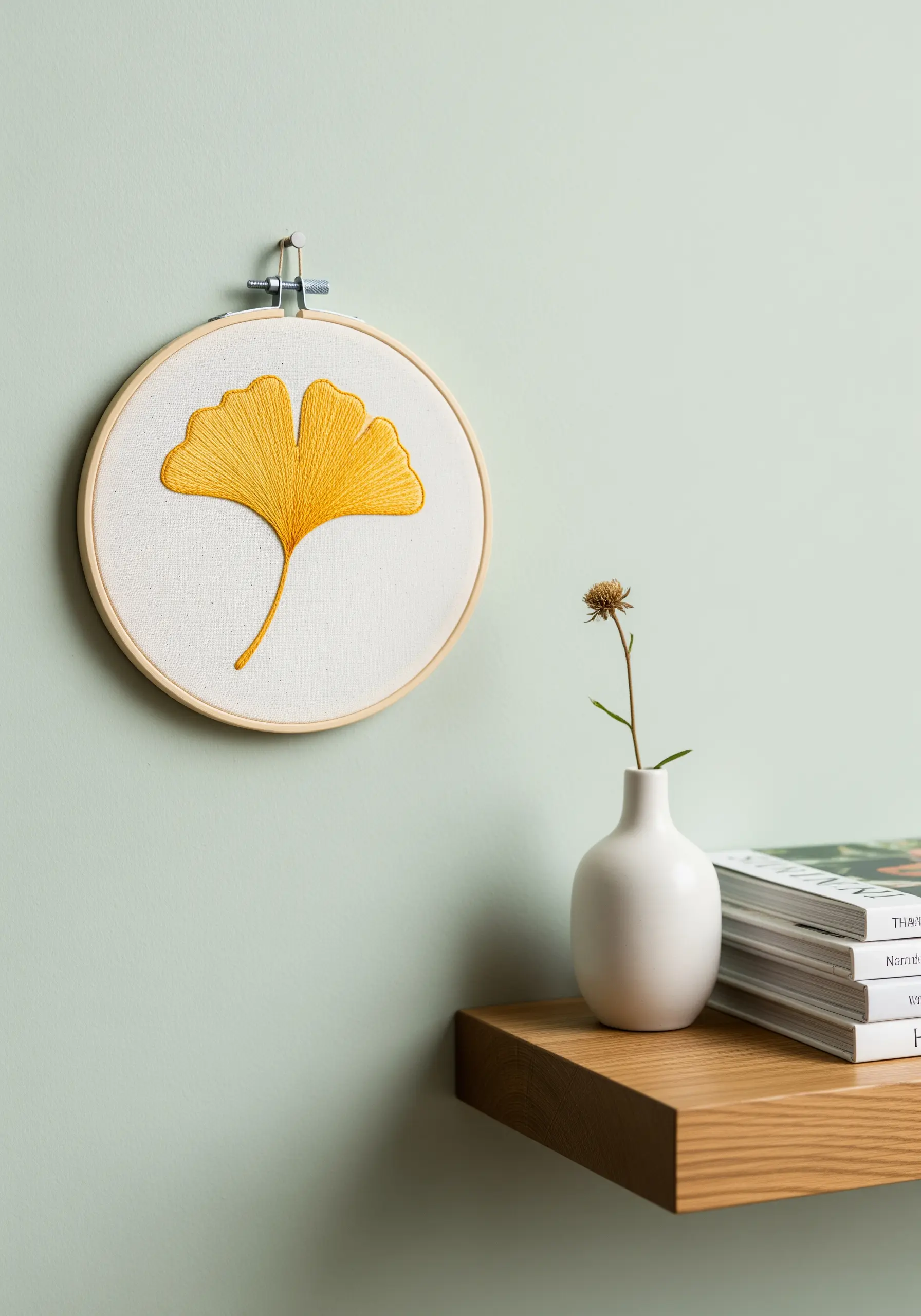 A single ginkgo leaf embroidered in yellow thread using directional long-and-short stitch.