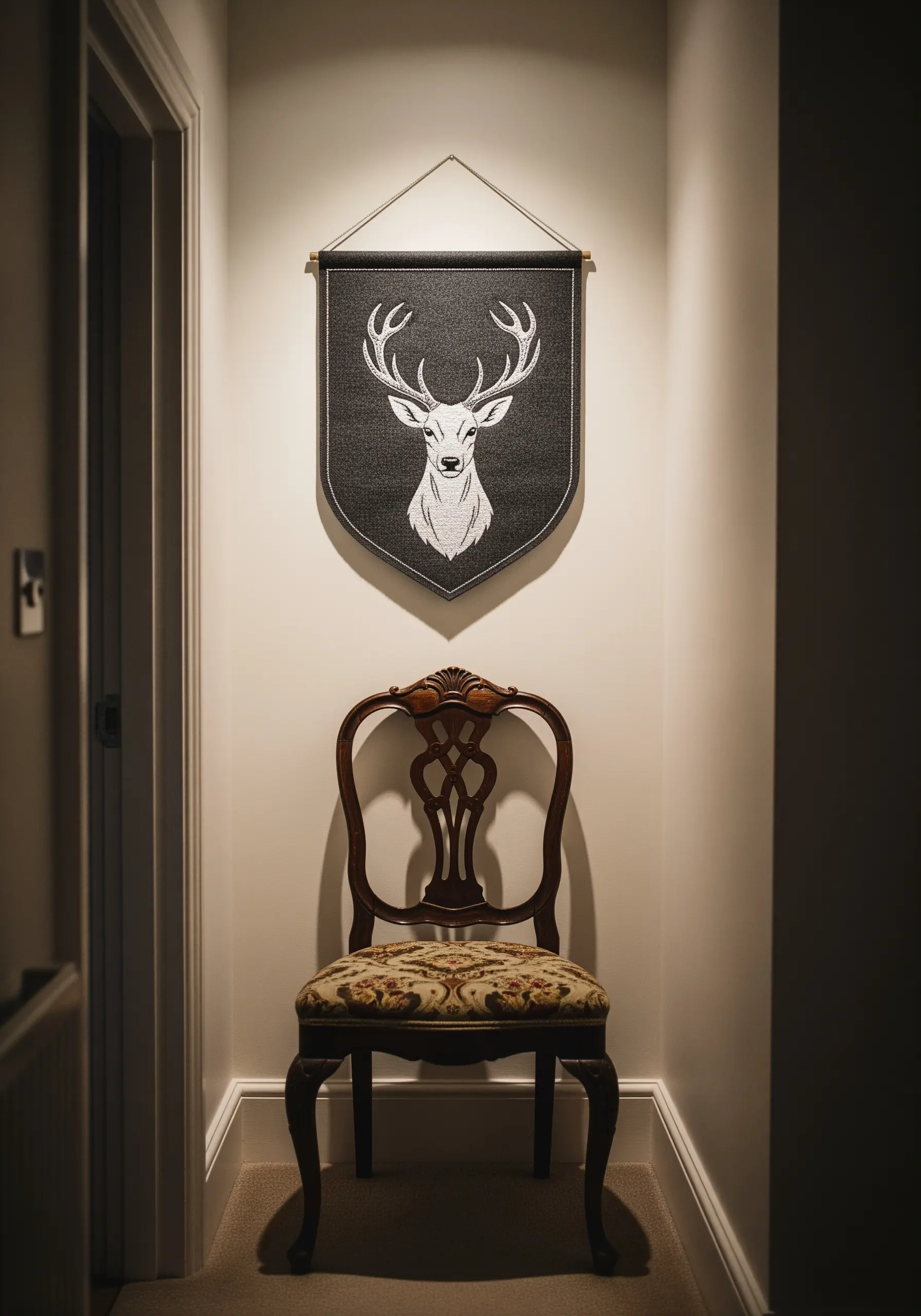 A striking white stag head embroidered on a dark charcoal banner.