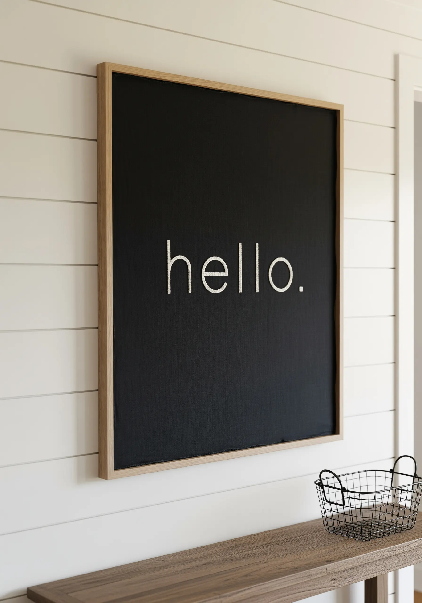 The word 'hello' embroidered in thin white thread on a large black canvas.