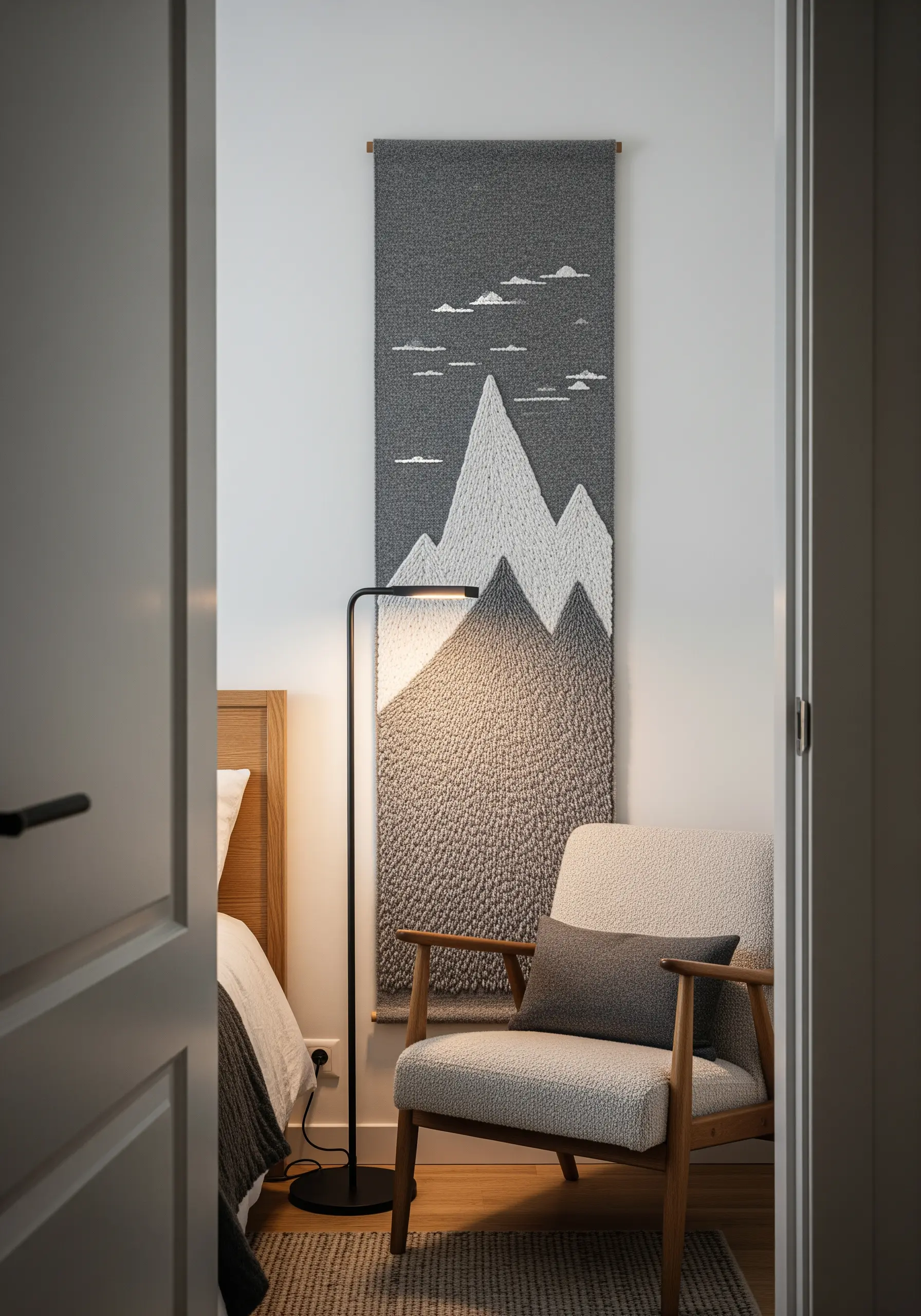 Monochrome embroidered wall hanging of mountains with directional fill stitches.