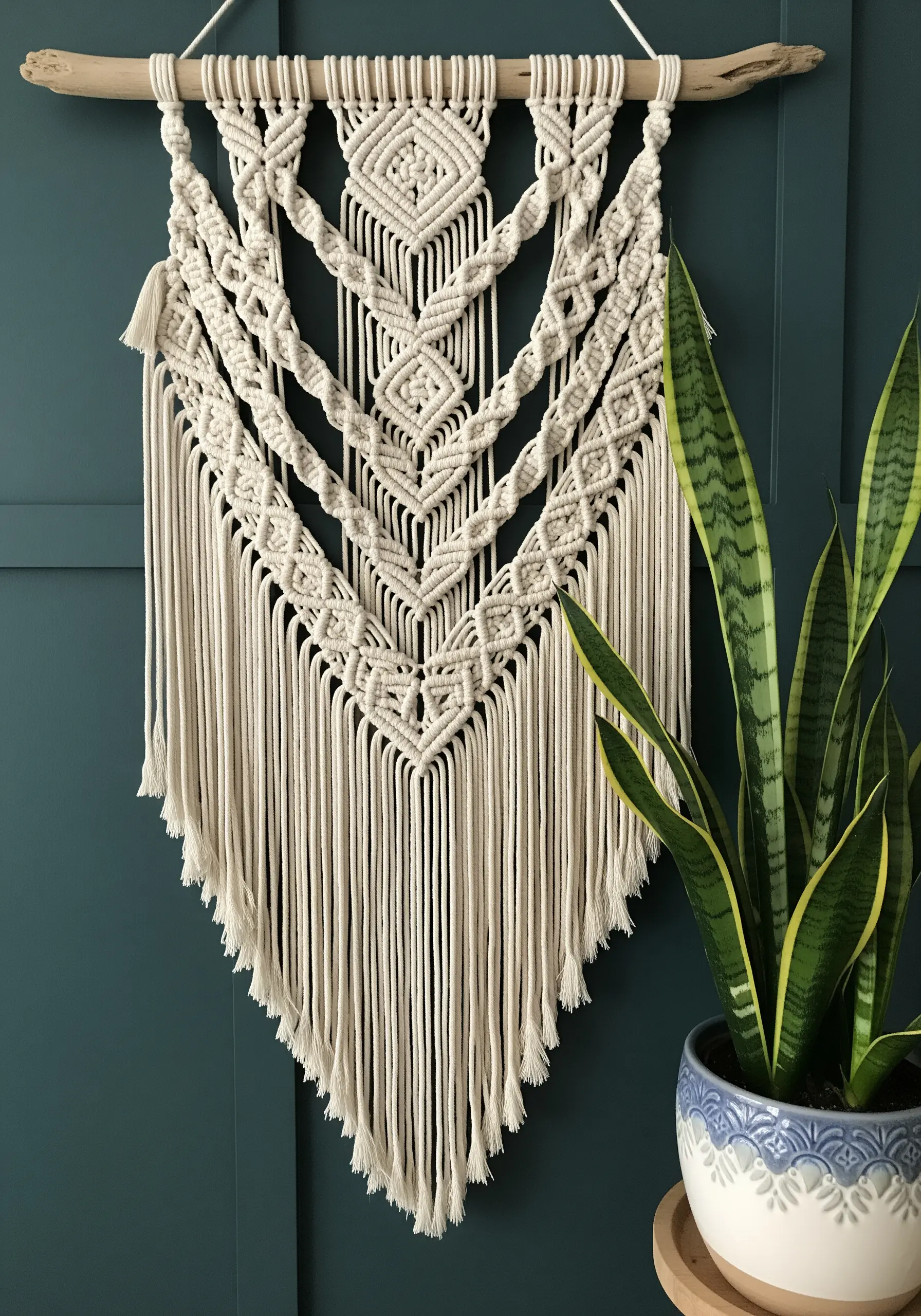 Large layered macrame wall hanging with intricate diamond and V-shaped knot patterns.