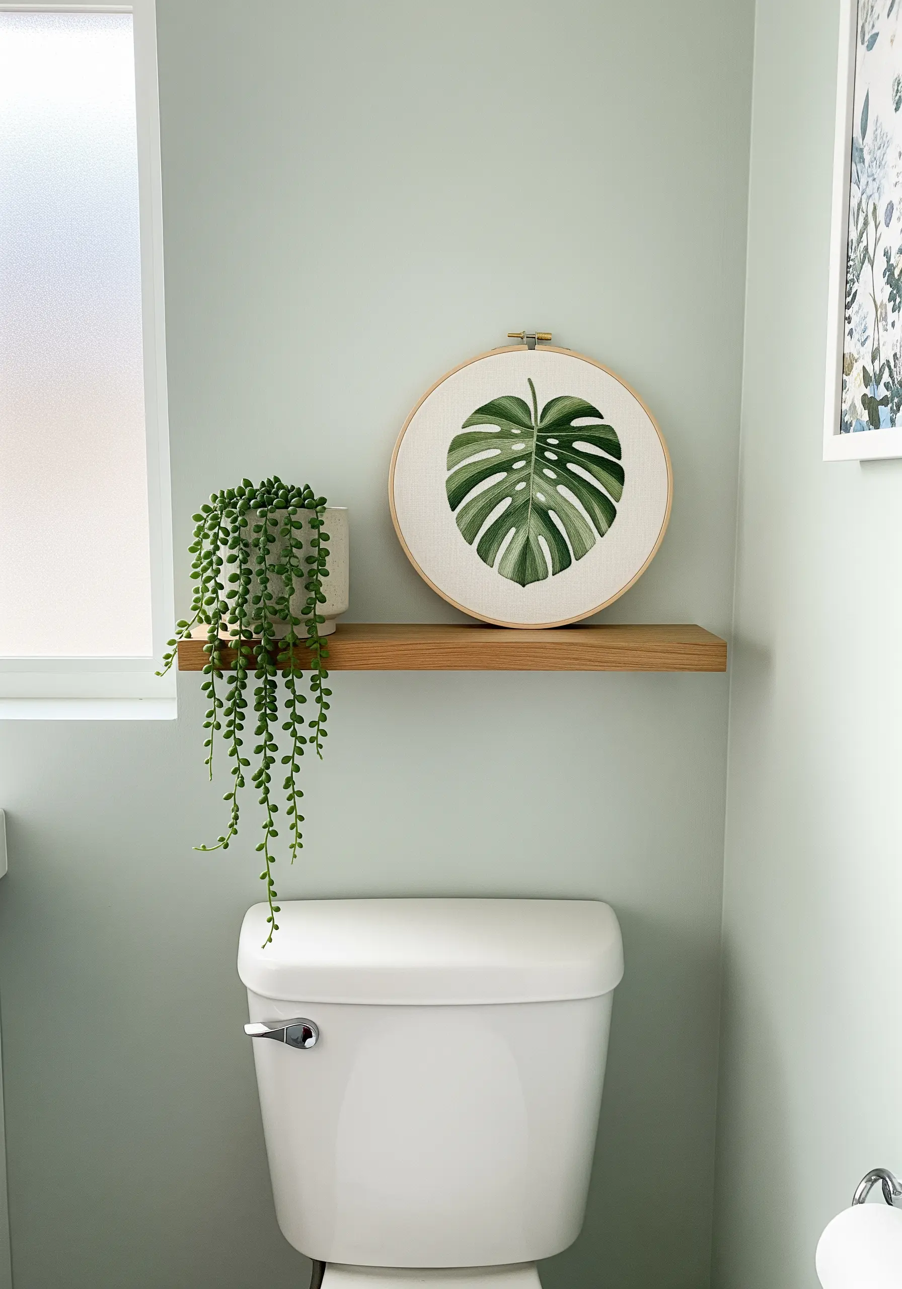 Thread-painted monstera leaf in a wooden hoop, showing color blending.