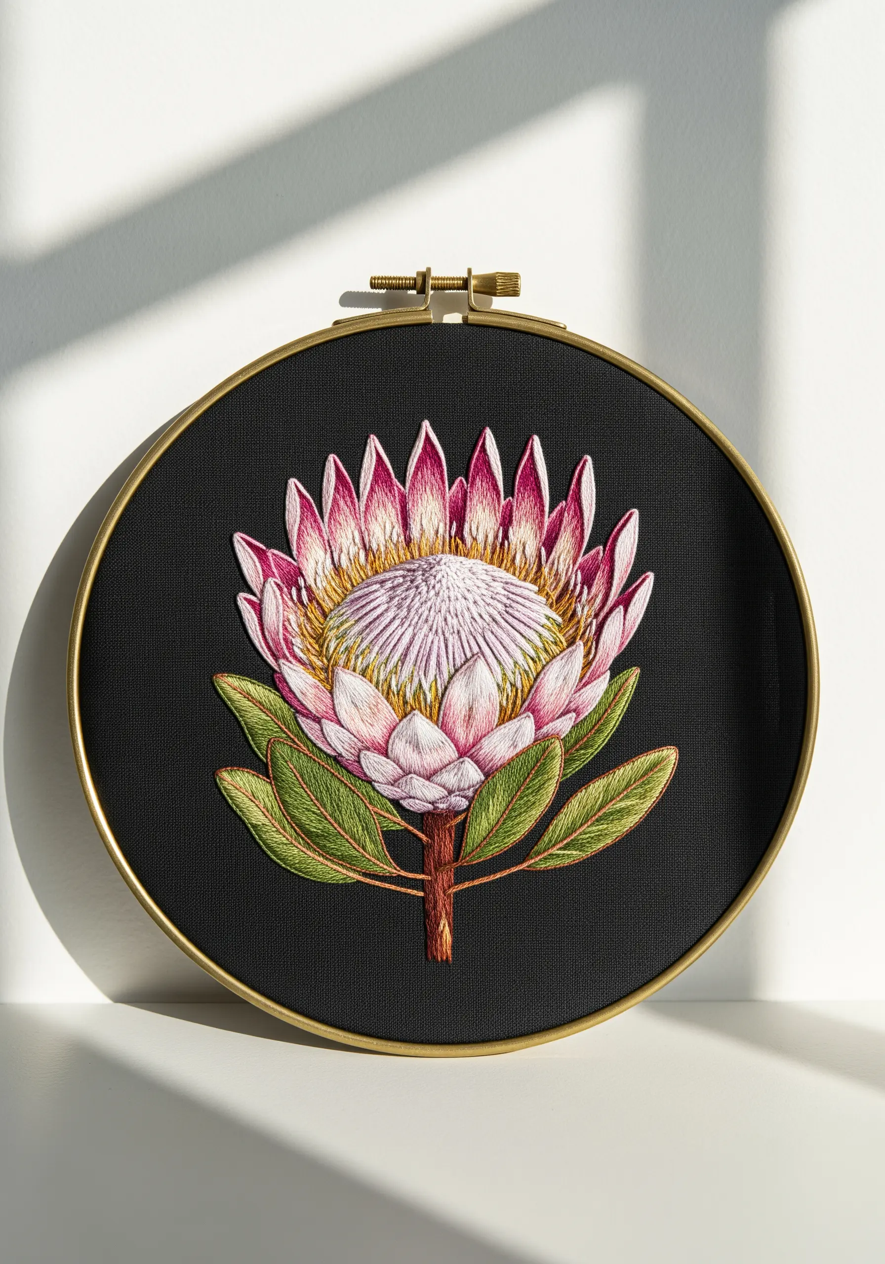 A hyper-realistic embroidered Protea flower on black fabric, showcasing thread painting.