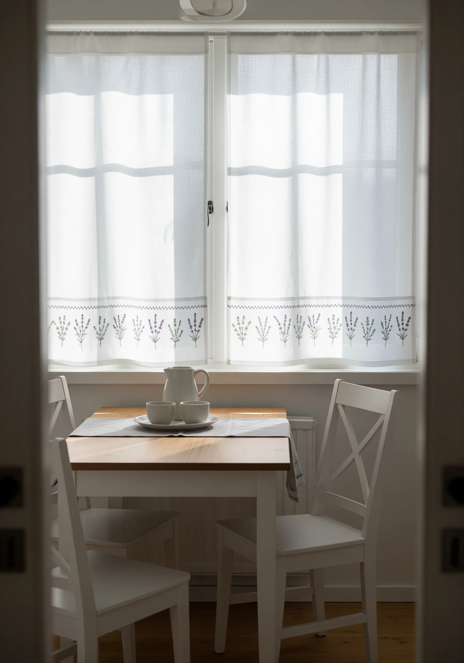 A simple embroidered lavender border on a sheer white kitchen curtain.