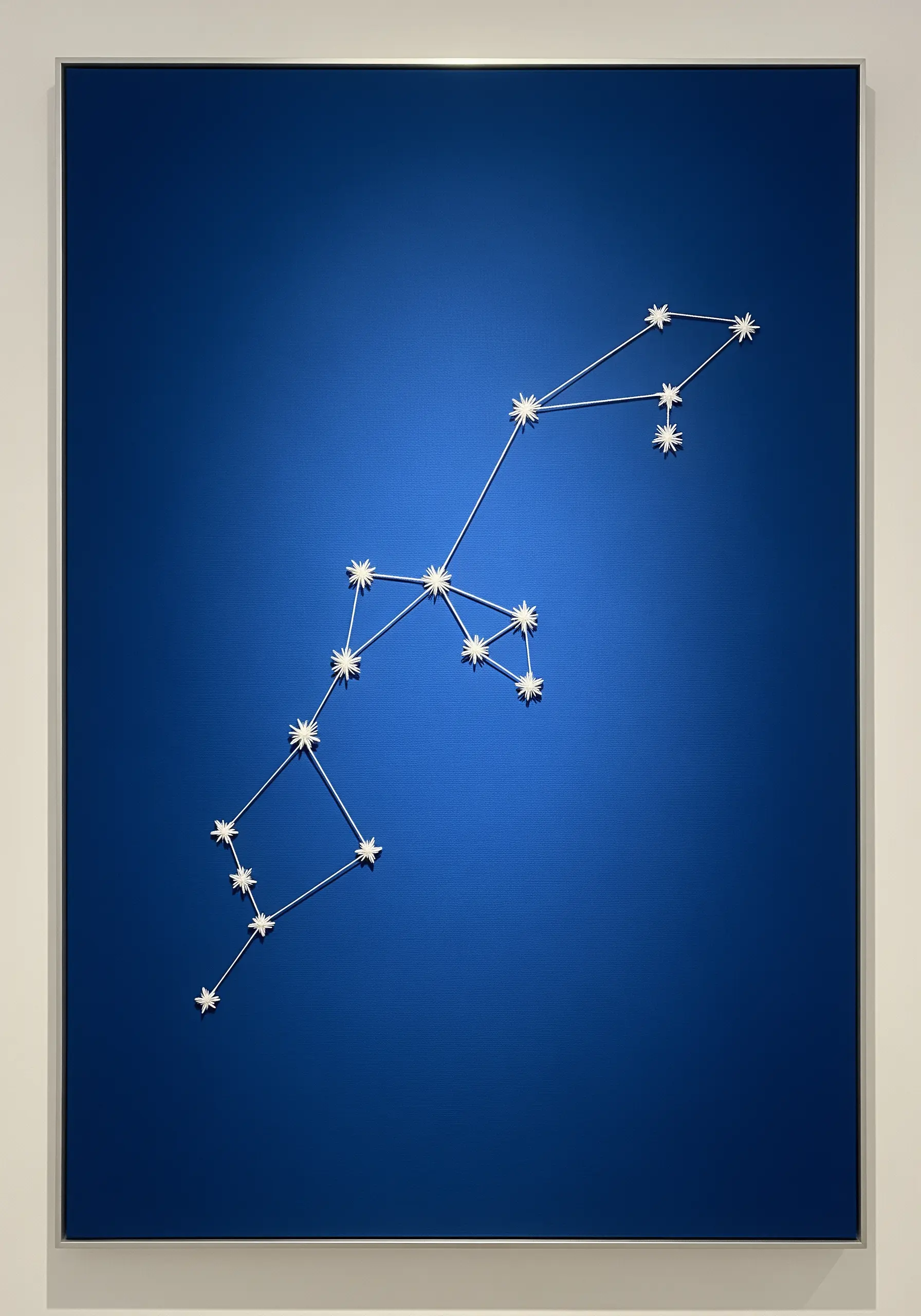 Deep blue canvas with white thread depicting a constellation diagram