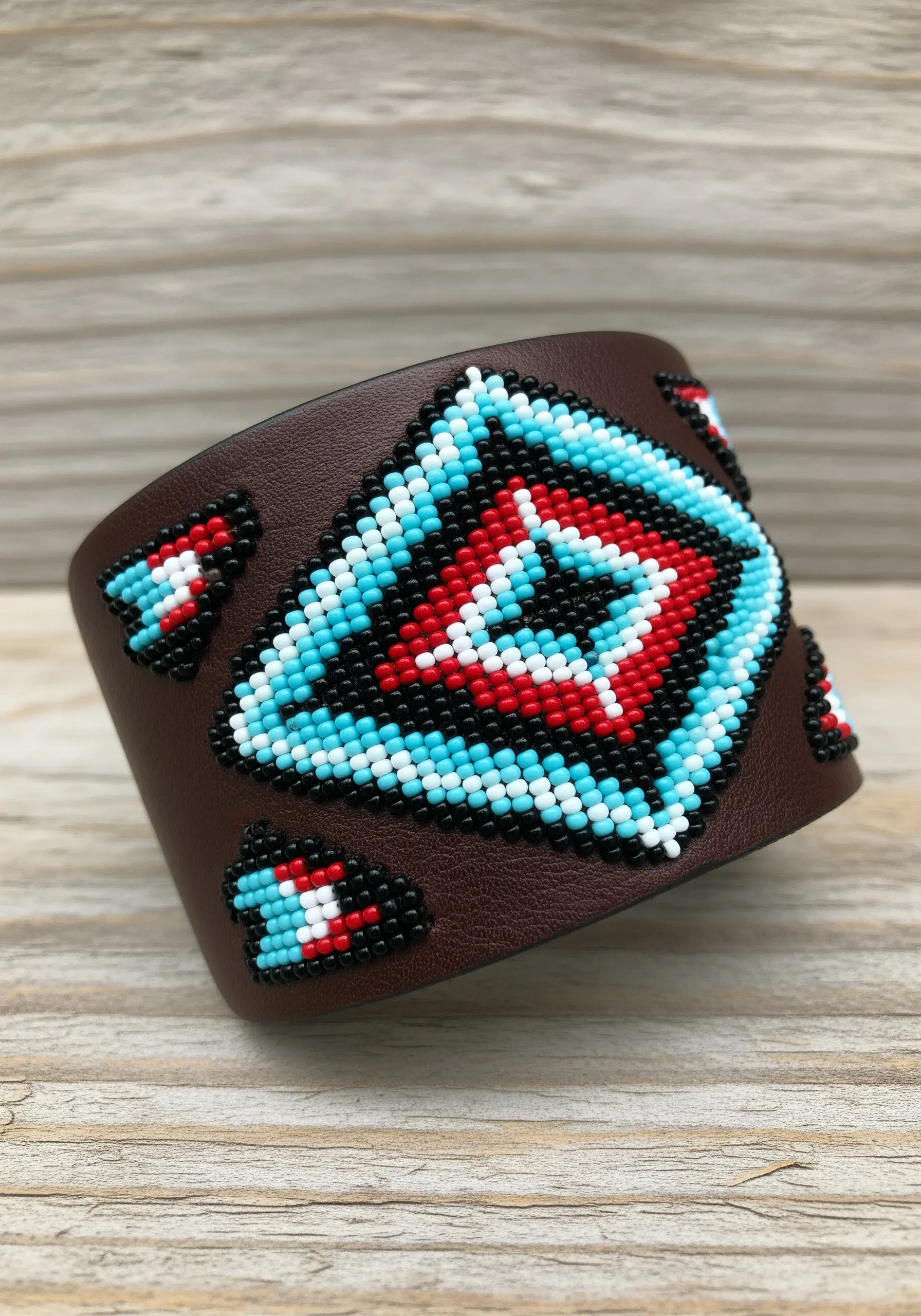 A leather cuff with a geometric pattern in the style of Native American beadwork.