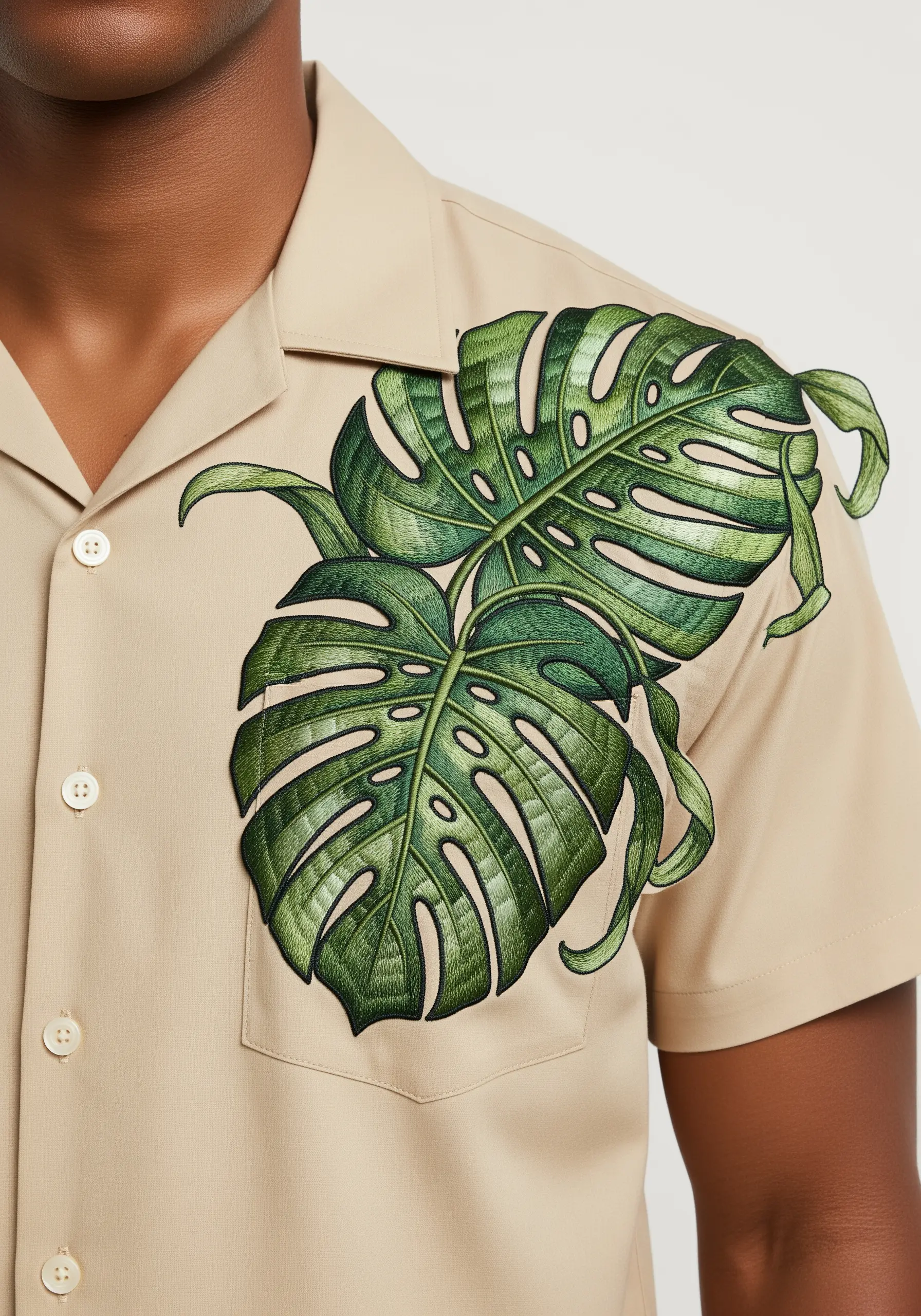 Large, detailed monstera leaves embroidered over the pocket and onto the shoulder of a shirt.