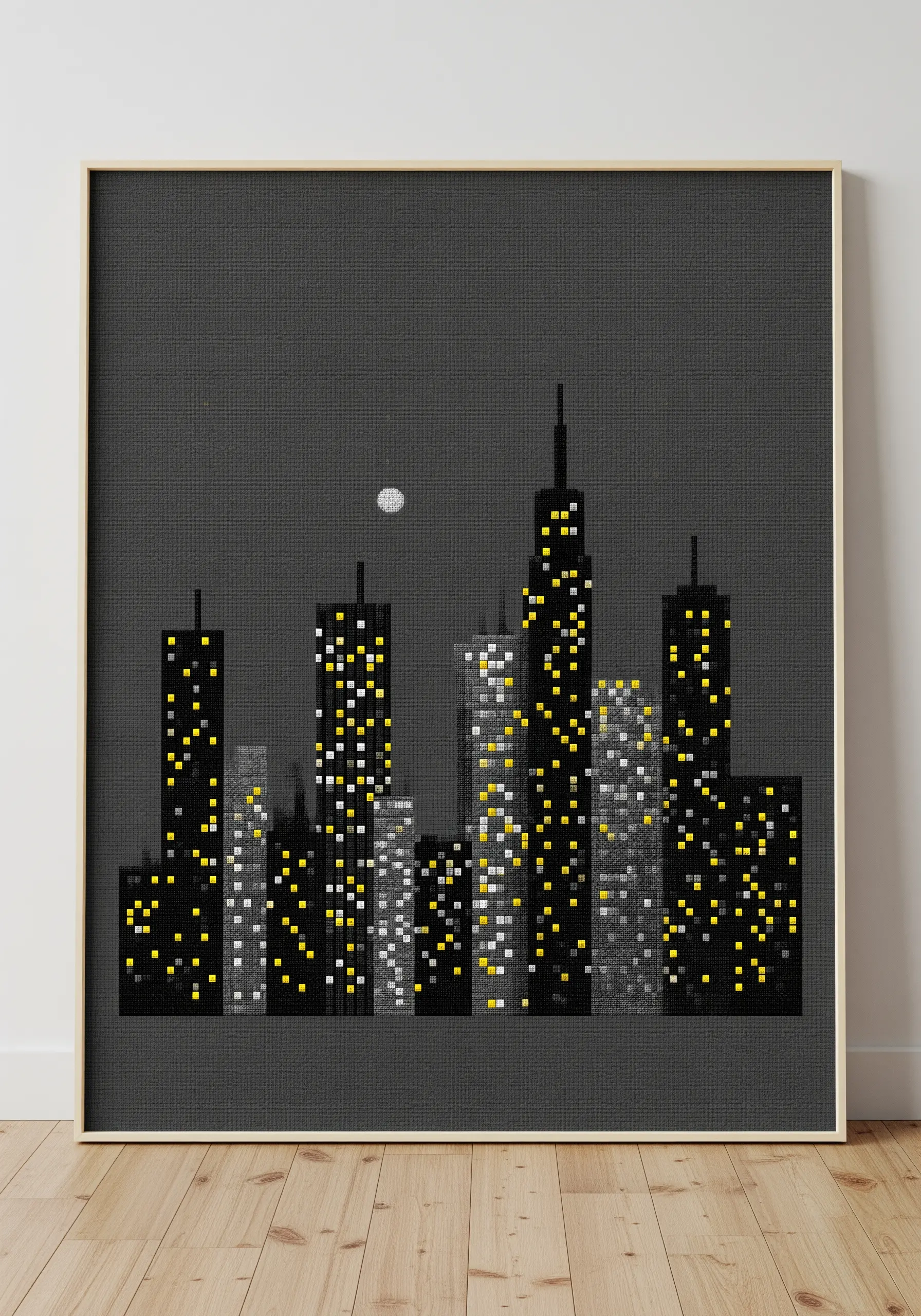 Cross-stitch of a city skyline at night with glowing yellow and white window stitches.