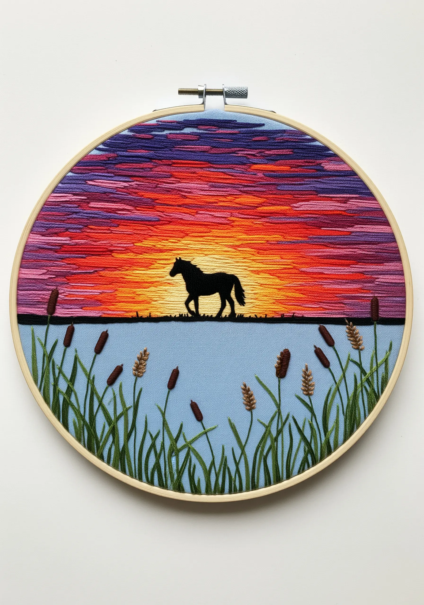 Black horse silhouette against a vibrant, thread-painted sunset embroidery hoop.