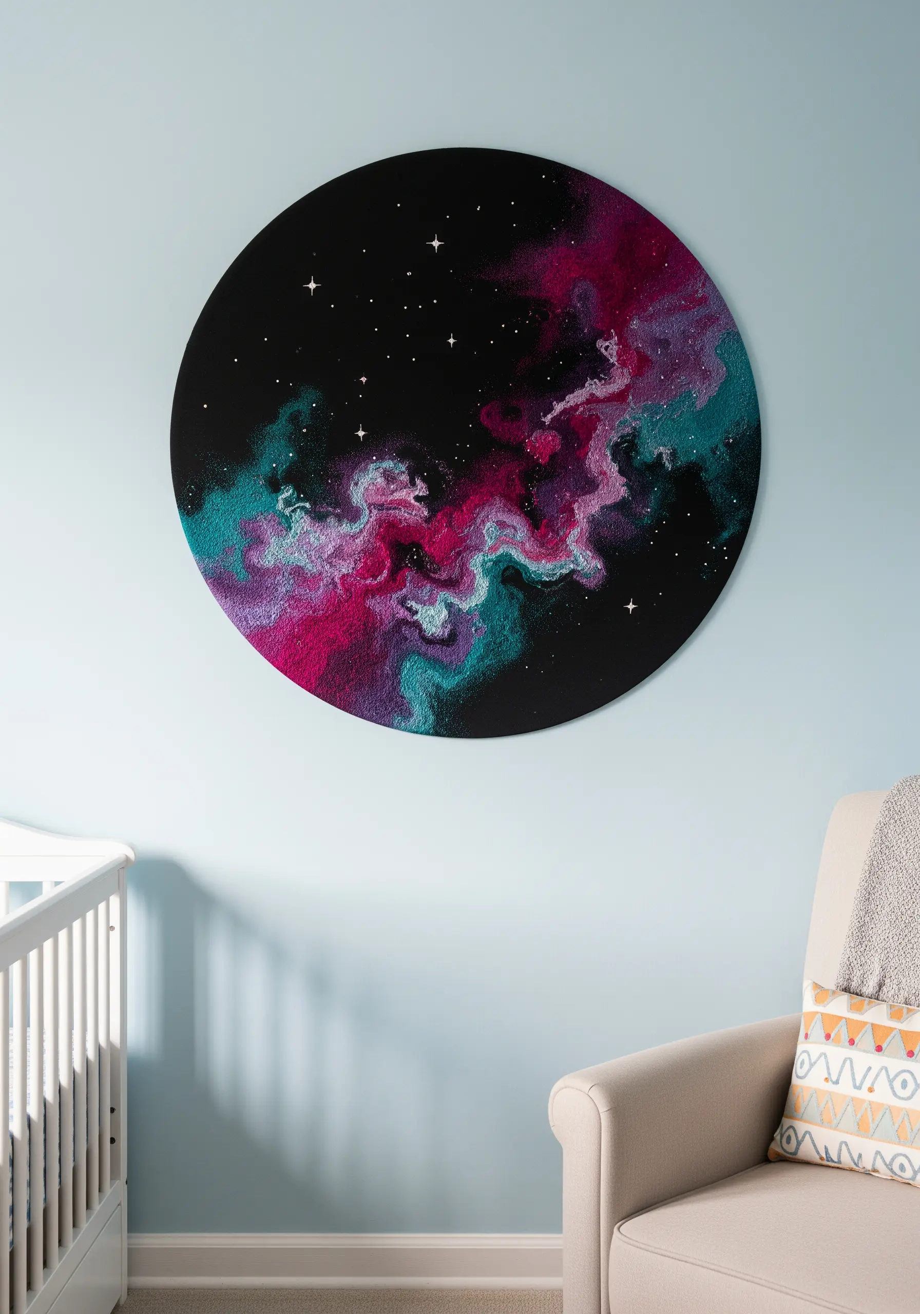 A large, circular embroidery of a pink and teal nebula in a nursery.