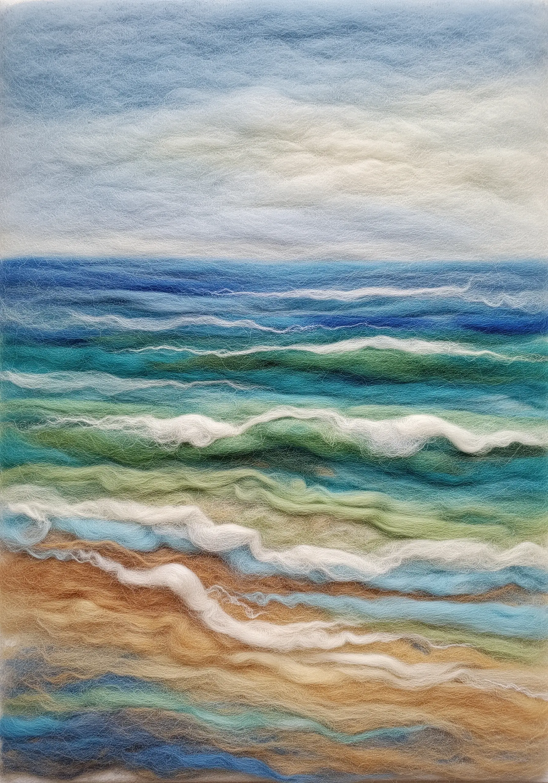 A needle-felted seascape with soft, blended colors depicting the sky, ocean waves, and sand.