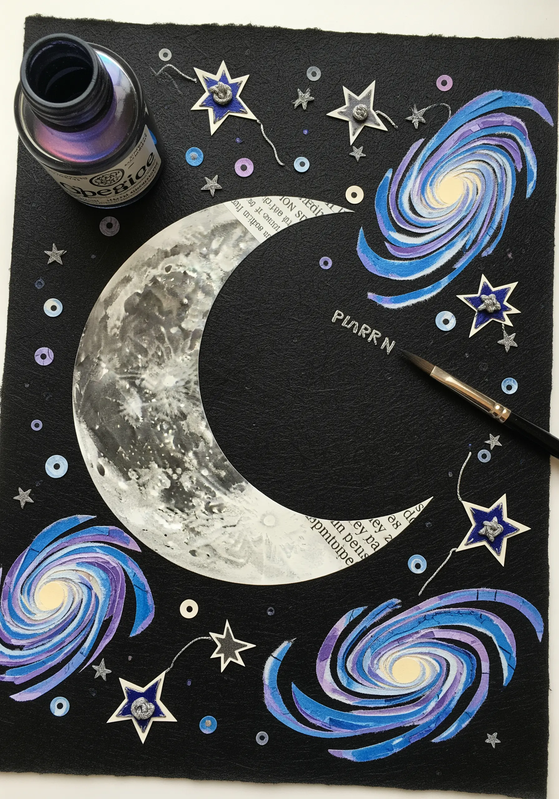 A celestial collage with a paper moon and swirling paper galaxies on a black background.
