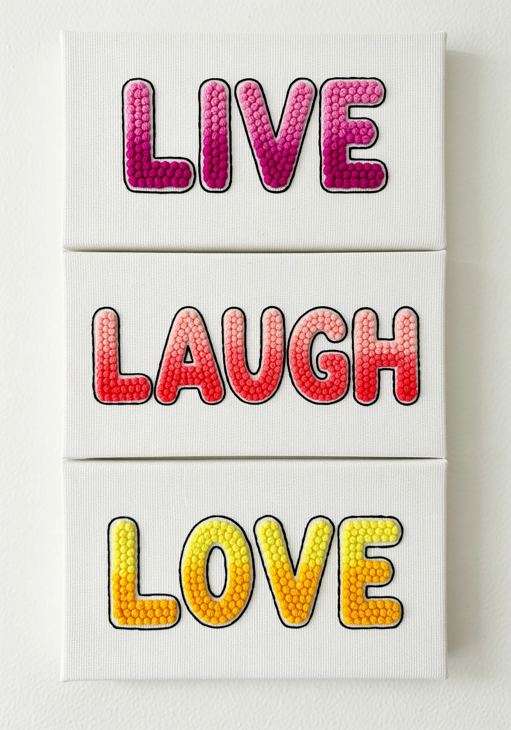 Letters filled with pink, red, and yellow gradient French knots on three white canvases.