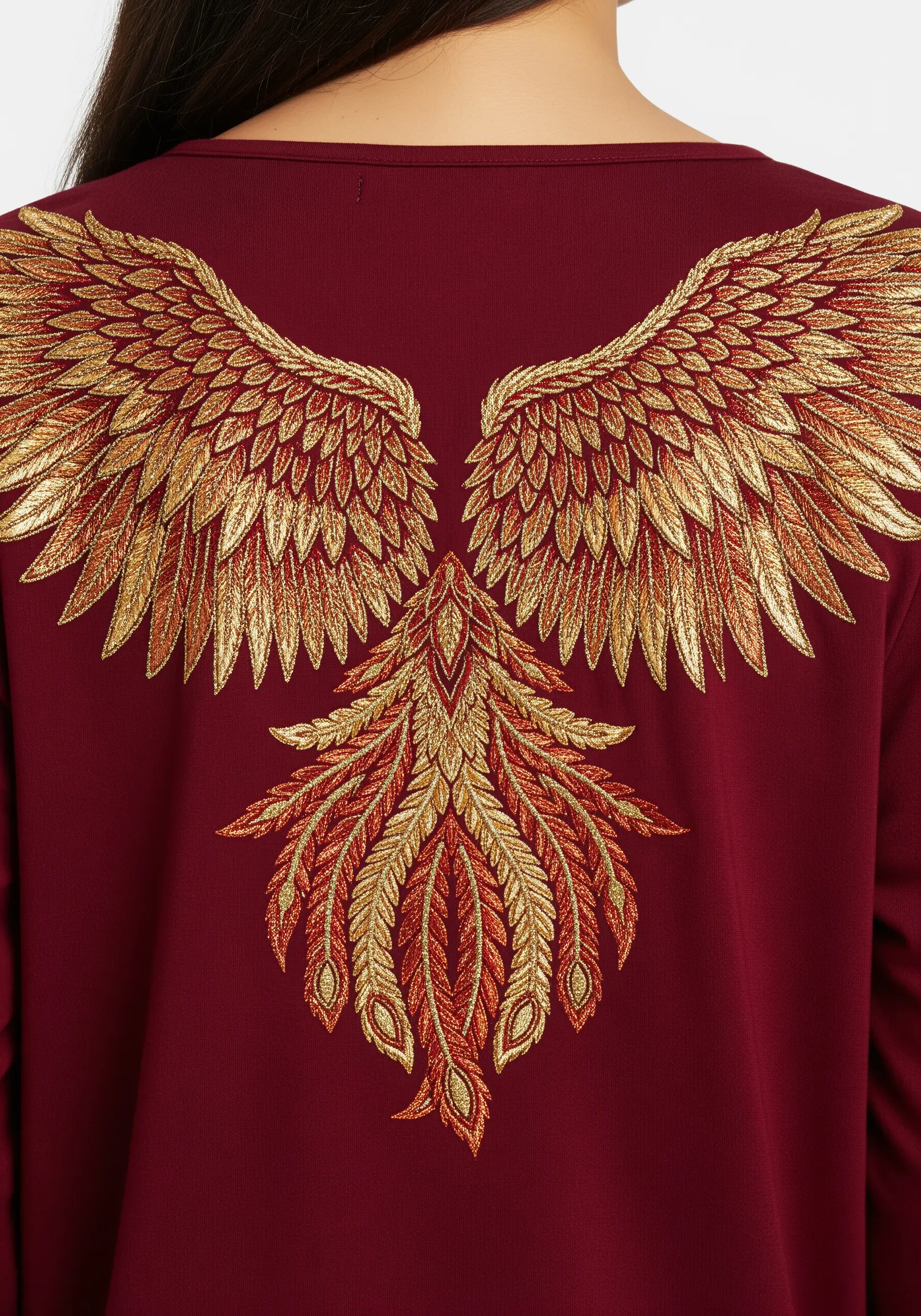 Large, detailed phoenix wings in red and gold ombré glitter thread on a maroon top.